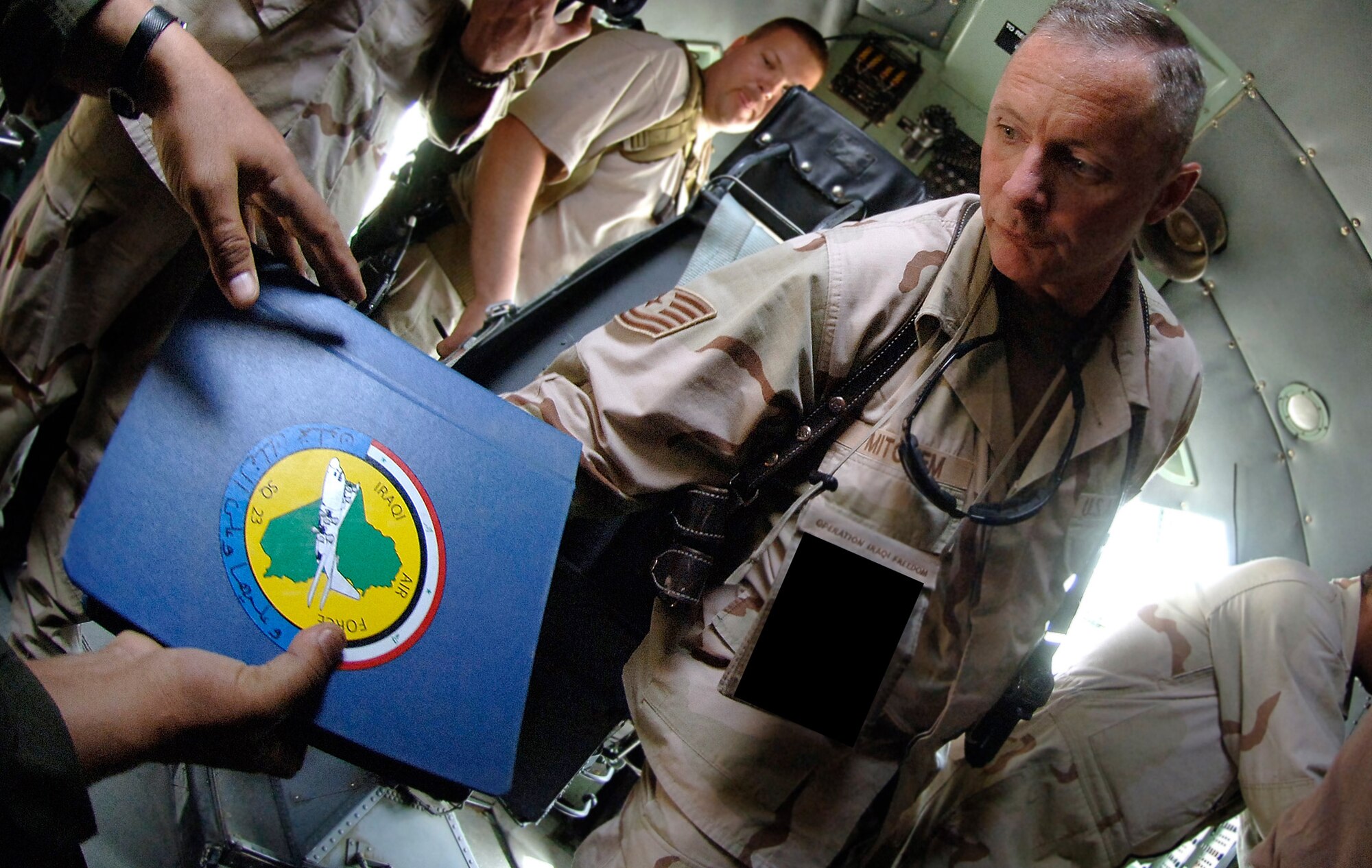Tech. Sgt.  Robert Mitchem is handed an Iraqi technical manual to help him mentor Iraqi Airmen on proper repair of an Iraqi Air Force C-130 Hercules navigational panel element. Sergeant Mitchem is assigned to the 370th Air Expeditionary Advisory Squadron at New Al Muthana Air Base, Baghdad, Iraq. The squadron's mission is to restart the Iraqi Air Force. (U.S. Air Force photo/Tech. Sgt. Cecilio M. Ricardo Jr.)
