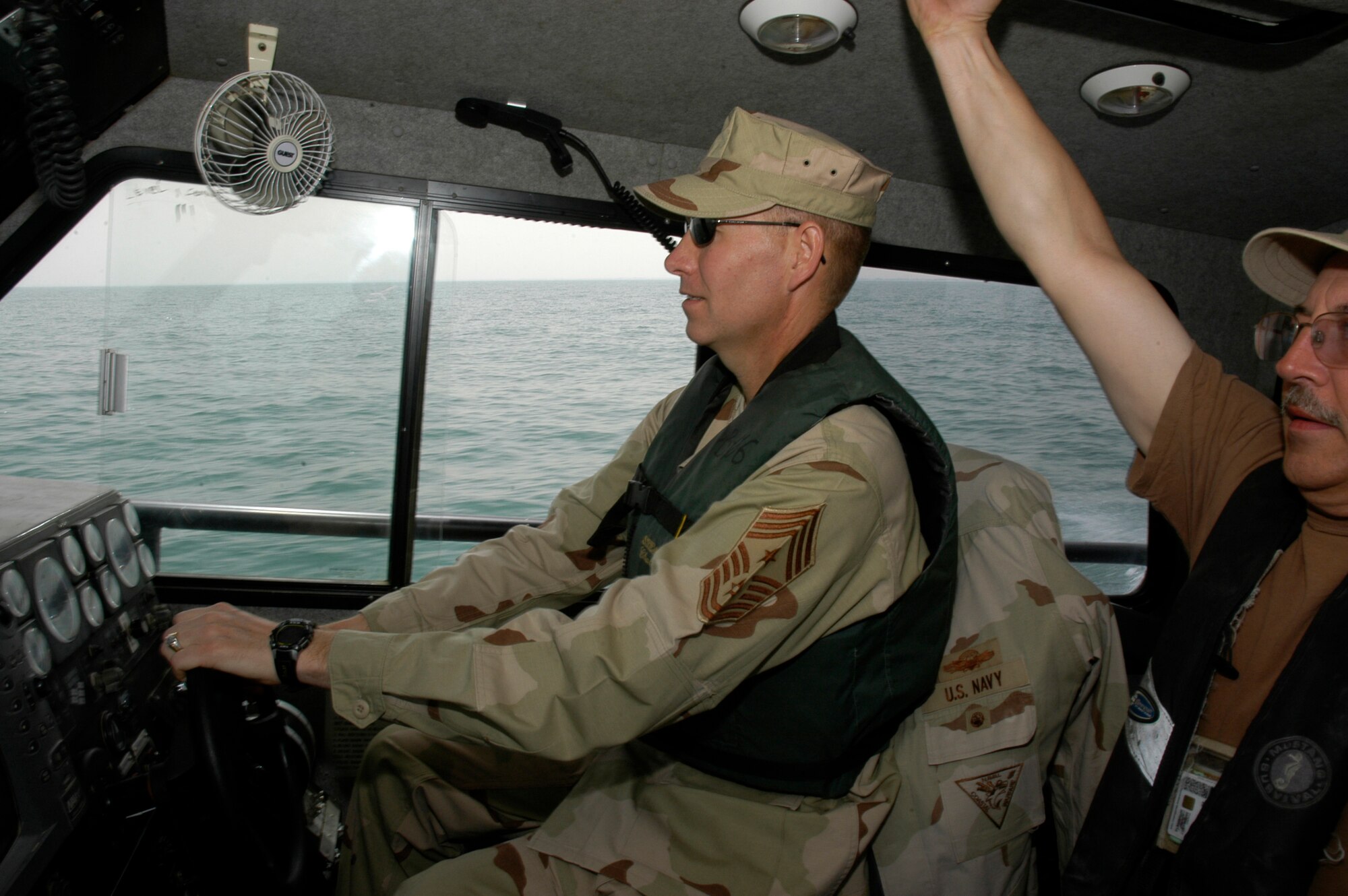 SOUTHWEST ASIA -- Chief Master Sgt. Richard Small, CENTAF Command Chief, gets an oportunity to pilot a Navy boat during a tour of Camp Patriot. Camp Patriot is an Air Force run camp situated on a Naval base at an undisclosed location in Southwest Asia.  Camp Bucca is one of the many places in the CENTCOM AOR where Airmen are doing non-traditional jobs. (AF photo/Staff Sgt. Ian Carrier)                        