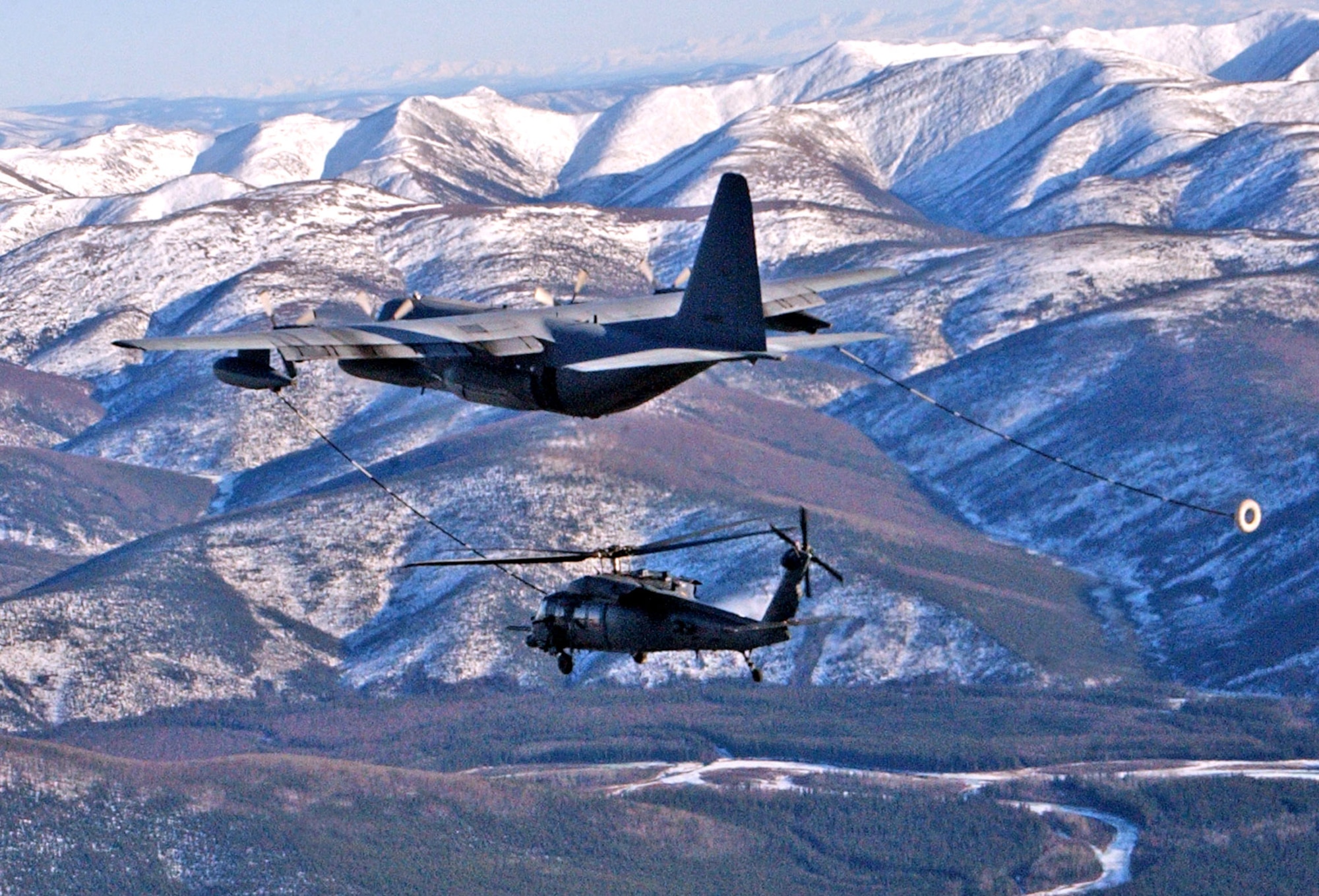 An HC-130 Hercules refuels an HH-60G Pave Hawk helicopter April 17 during a combat search and rescue training mission Red Flag-Alaska 07-1 at Eielson Air Force Base, Alaska. The helicopters are assigned to the 210th Rescue Squadron Det. 1. (U.S. Air Force photo/Senior Airman Justin Weaver)