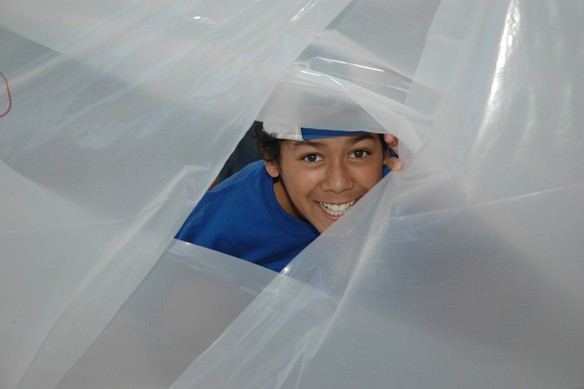 EGLIN AIR FORCE BASE, Fla. -- Levon Swafford, 11, a fifth grader from Cherokee Elementary School, peeks out of his plastic shelter. Fifth-grade students from three elementary schools kicked off the Marsville Project culminating six weeks of study about space. The project required students from Cherokee, Valparaiso and Longwood Elementary Schools to experience a day of living in "space" by building a habitat. During the weeks prior to Marsville, students learned about the life support systems to consider before travel into space, such as the need for air, water, transportation and garbage disposal. Each student built a life support system model to bring with them. (U.S. Air Force photo by Staff Sgt. Mike Meares)