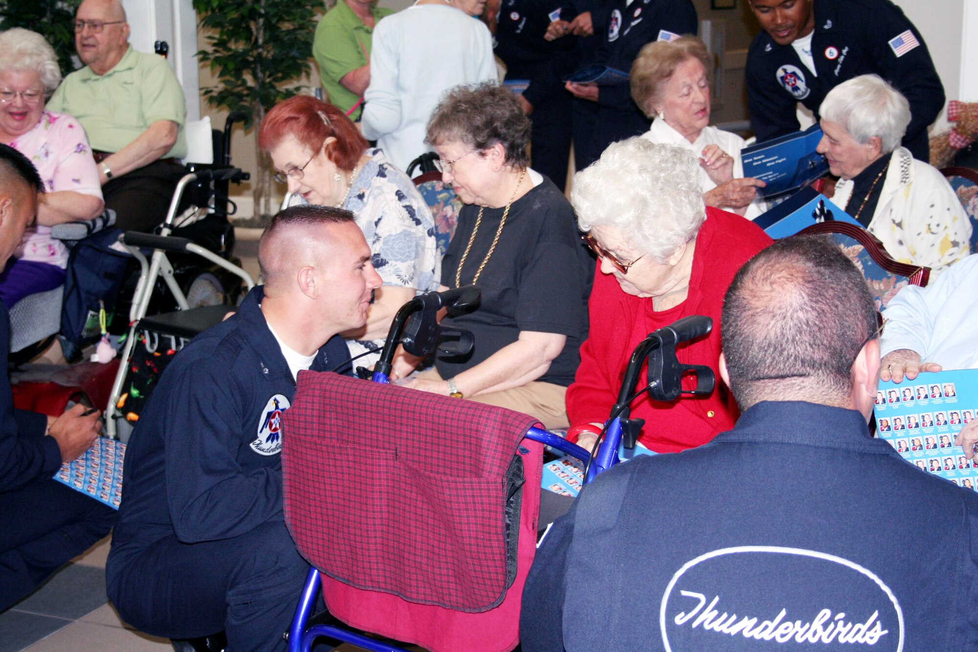 Aircrew members of the Thunderbirds, the Air Force's air demonstration team, visit with residents at Hawthorn House, the Air Force Enlisted Village's assisted living residence in Shalimar, Fla. When inclement weather caused the Eglin Air Show to be cancelled April 14, the Thunderbirds made a surprise visit to the Enlisted Village, a charity that provides a home for widows of enlisted servicemembers. (Courtesy photo)