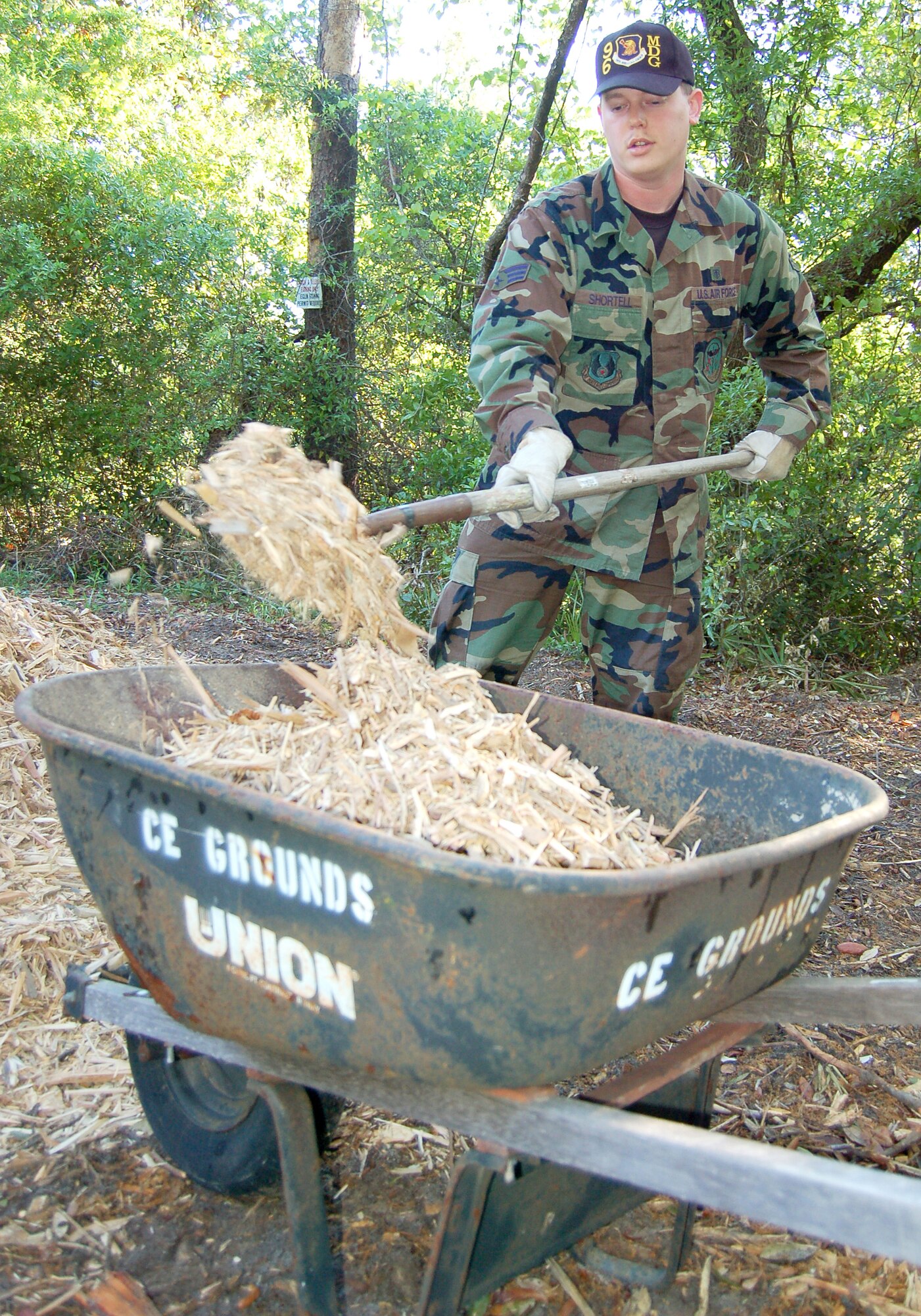 EGLIN AIR FORCE BASE, Fla. -- Senior Airman John Shortell, 96th Aerospace Medicine Squadron bio-environmental technician, loads a wheel barrel with mulch that was spread on the Memorial Trail during Eglin's Earth Day April 19.