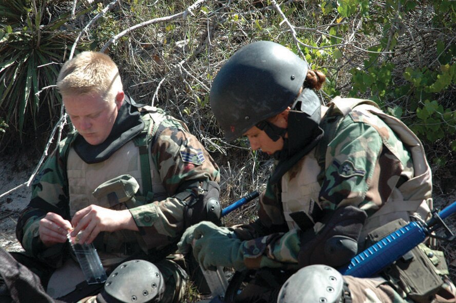 Two ECST students refill their magazines after a combat training scenario. (U.S. Air Force photo by 2nd Lt. Lauren Johnson)