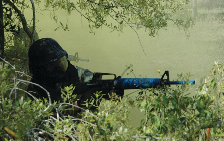 ECST students take cover in the brush under the haze of a smoke bomb during the combat training scenario. (U.S. Air Force photo by 2nd Lt. Lauren Johnson)