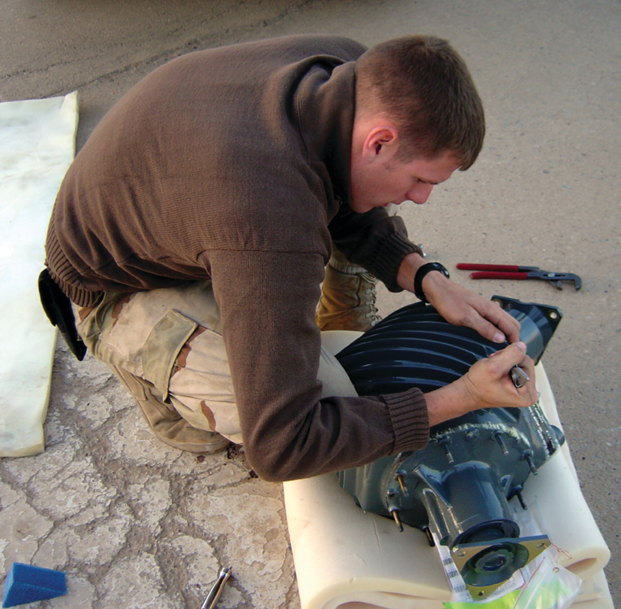 Senior Airman Tim Stumpf, 1st Special Operations Helicopter Maintenance Squadron, works on a helicopter part in a deployed location. (Courtesy photo)