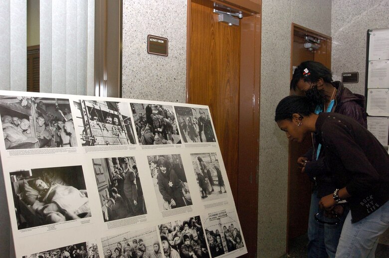 Guests at the Holocaust Remembrance Ceremony look at photo displays depicting some of the occurrences during that time period at Yokota Air Base's East Chapel April 20 in Japan. This year's celebration theme was "Remembering the past for a better future." (U.S. Air Force photo/Airman Leandra Hernandez)