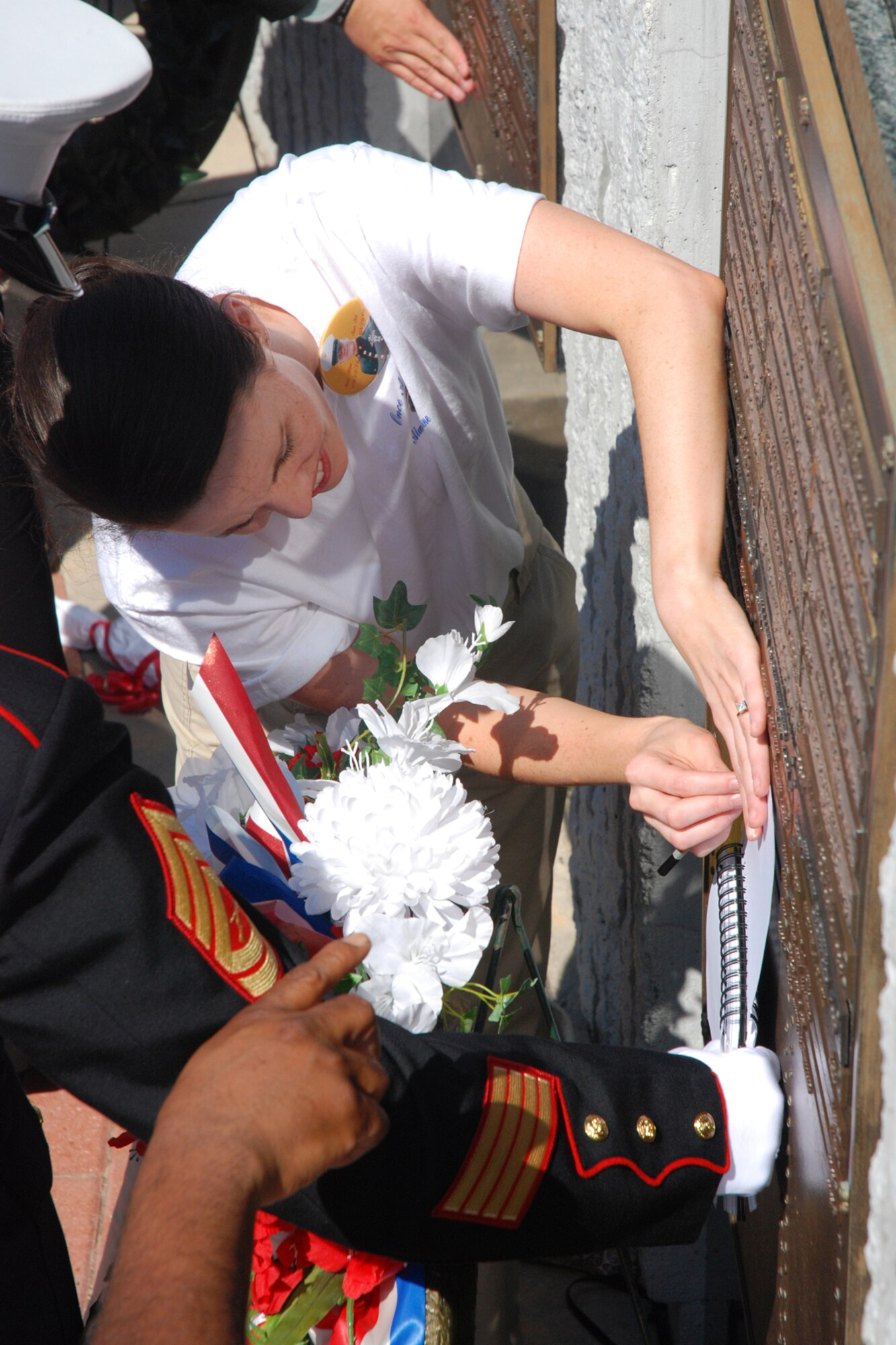 EGLIN AIR FORCE BASE, Fla. -- Sara Dennis, the "adopted sister" to U.S. Marine Corps Sgt. John P. Phillips, gets an etching of his name on a blank sheet of paper during the Explosive Ordnance Disposal 38th Annual Memorial Service at the Kauffman EOD Training Complex April 21. Sergeant Phillips was severely wounded by an improvised explosive device attack near Fallujah, Iraq, March 7, 2006. Although he "tenaciously" fought for several months, he succumbed to his wounds Aug. 16, 2006. The ceremony memorialized 14 names of Soldiers, Sailors, Airmen, Marines and Coast Guardsmen who have sacrificed their lives during EOD missions. Those names will bring the total to 215 names inscribed on the bronze tablets of the memorial. (U.S. Air Force photo by Staff Sgt. Mike Meares)