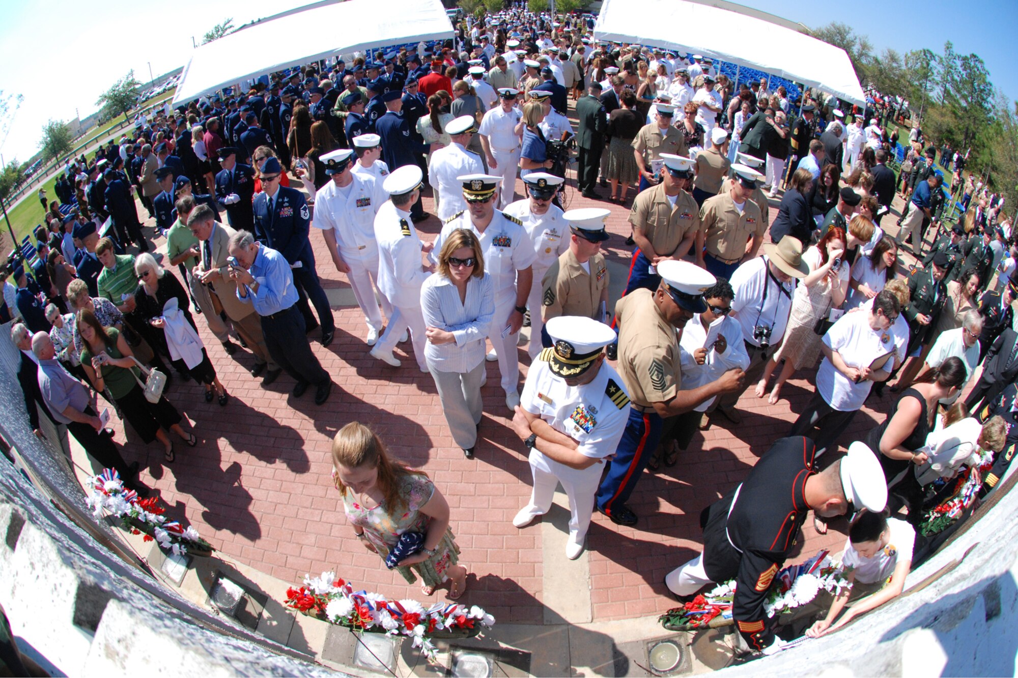 EGLIN AIR FORCE BASE, Fla. -- Family and friends gather around the memorial after the ceremony during the Explosive Ordnance Disposal 38th Annual Memorial Service at the Kauffman EOD Training Complex April 21. The ceremony memorialized 14 names of Soldiers, Sailors, Airmen, Marines and Coast Guardsmen who have sacrificed their lives during EOD missions. Those names will bring the total to 215 names inscribed on the bronze tablets of the memorial. (U.S. Air Force photo by Staff Sgt. Mike Meares)