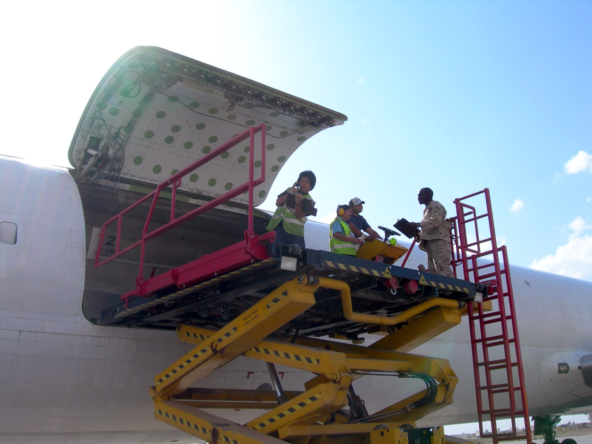 Senior Airman Brandon Reynolds and contractors load outgoing mail onto a cargo aircraft at Balad Air Base, Iraq. The Joint Military Mail Terminal sends out approximately 85,000 pounds of outgoing mail each week. Every day two aircraft deliver and pick up an average of 18 pallets of mail to and from the base. Airman Reynolds is assigned to the 332nd Expeditionary Communications Squadron. (U.S. Air Force photo/Capt. Ken Hall)