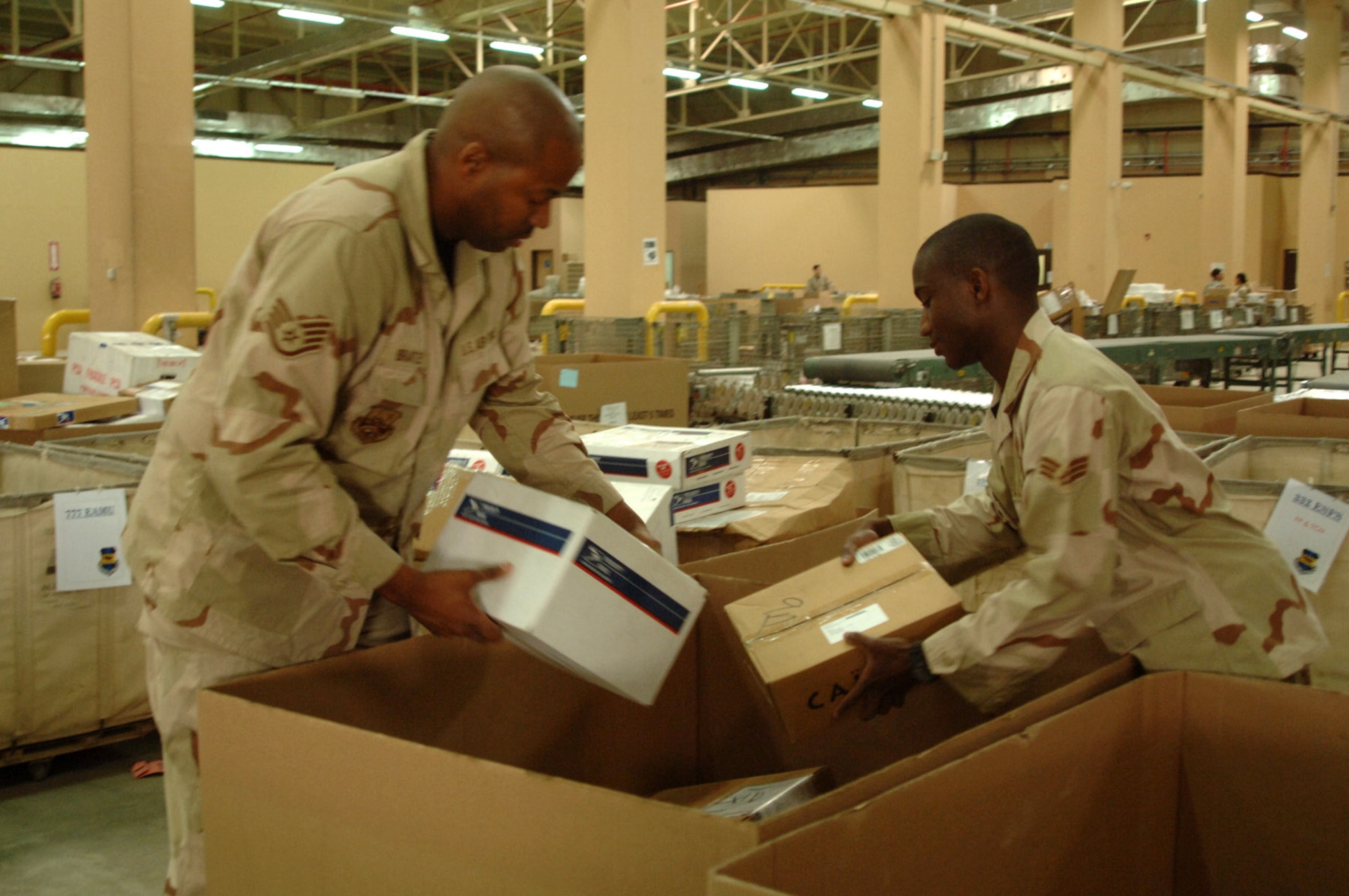 Staff Sgt. Kelvin Brantley (left) and Senior Airman Kevin Goldman sort inbound packages April 17 at the Joint Military Mail Terminal at Balad Air Base, Iraq. Airman at the JMMT receive approximately 325,000 pounds of incoming mail each week. Every day, two aircraft are used to deliver and pick up an average of 18 pallets of mail. The Airmen are assigned to the 332nd Expeditionary Communications Squadron. (U.S. Air Force photo/Capt. Ken Hall) 