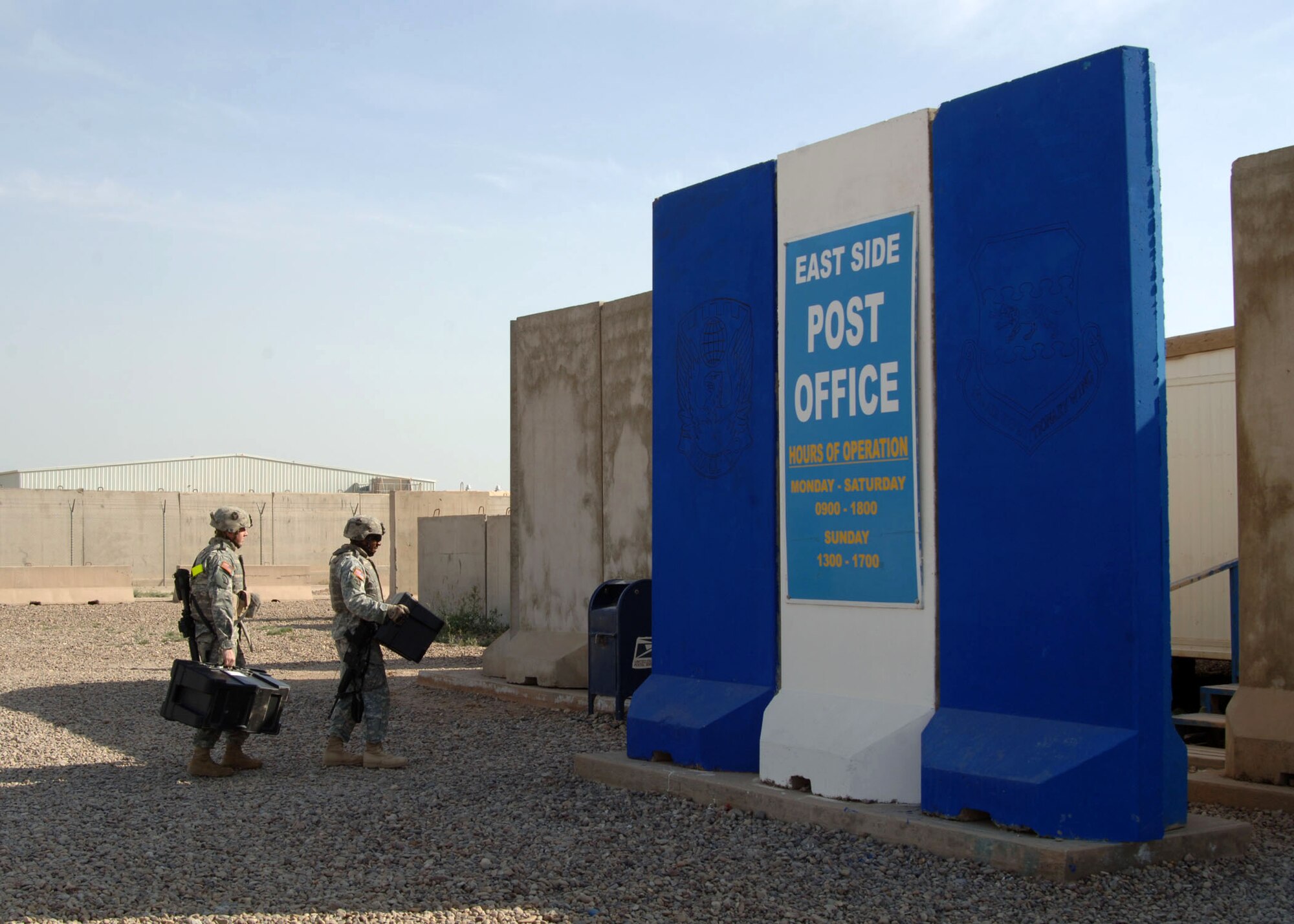 Two Soldiers enter the East Side Post Office April 17 at Balad Air Base, Iraq. The three postal facilities on Balad/Anaconda are responsible for more than 325,000 pounds of incoming and 85,000 pounds of outgoing mail each week, serving an average of 1,800 customers. Every day, two aircraft are used to deliver and pick up an average of 18 pallets of mail. (U.S. Air Force photo/Capt. Ken Hall)