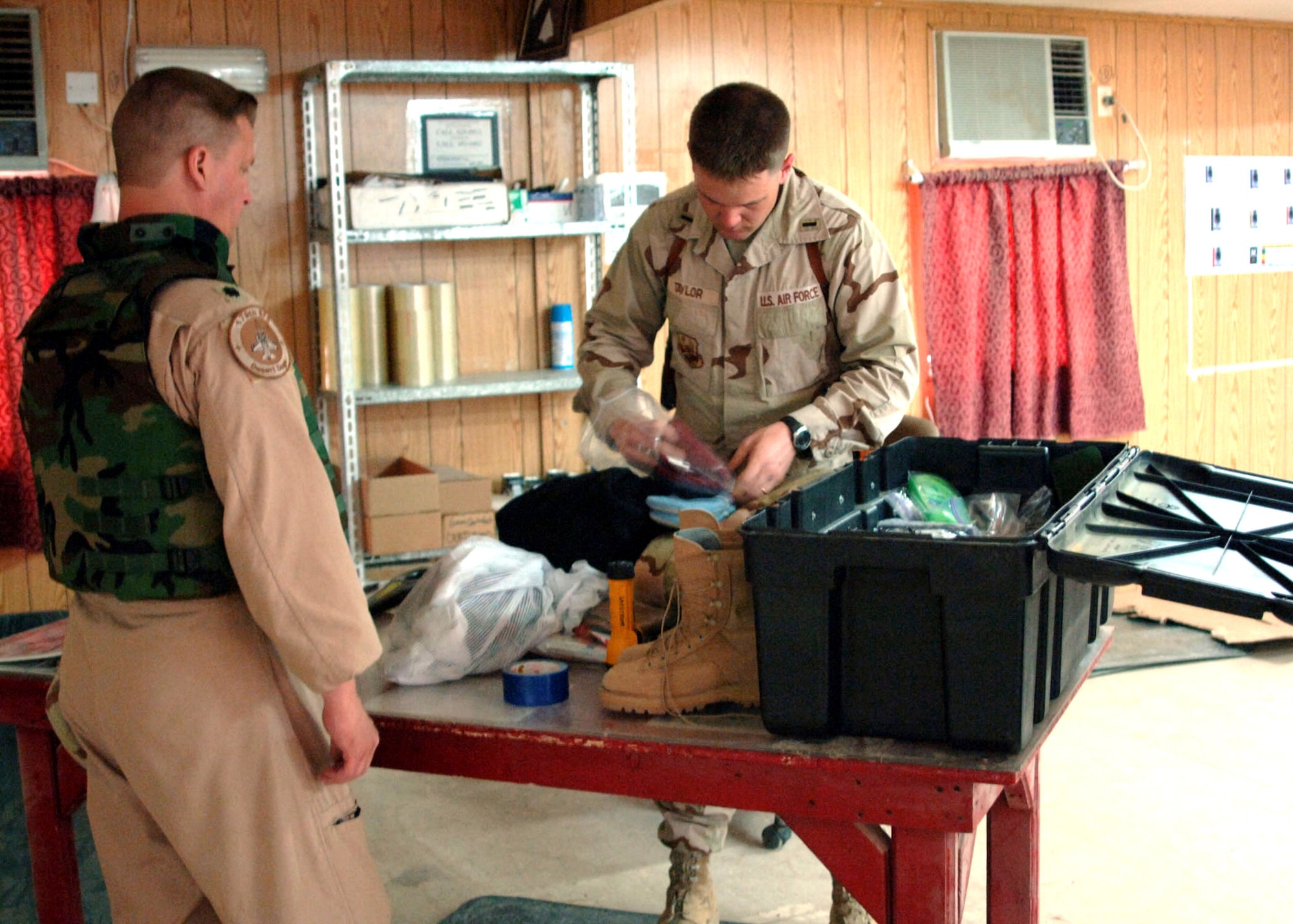 'Combat Postal' officer in charge 1st Lt. Lewis Taylor, 732nd Expeditionary Support Squadron, completes a mail inspection at one of the three post offices at Balad Air Base, Iraq. The lieutenant is in charge of 43 in-lieu-of Airmen responsible for more than 325,000 pounds of incoming and 85,000 pounds of outgoing mail each week, who serve an average of 1,800 customers. Every day, two aircraft are used to deliver and pick up an average of 18 pallets of mail. (U.S. Air Force photo/Capt. Ken Hall)