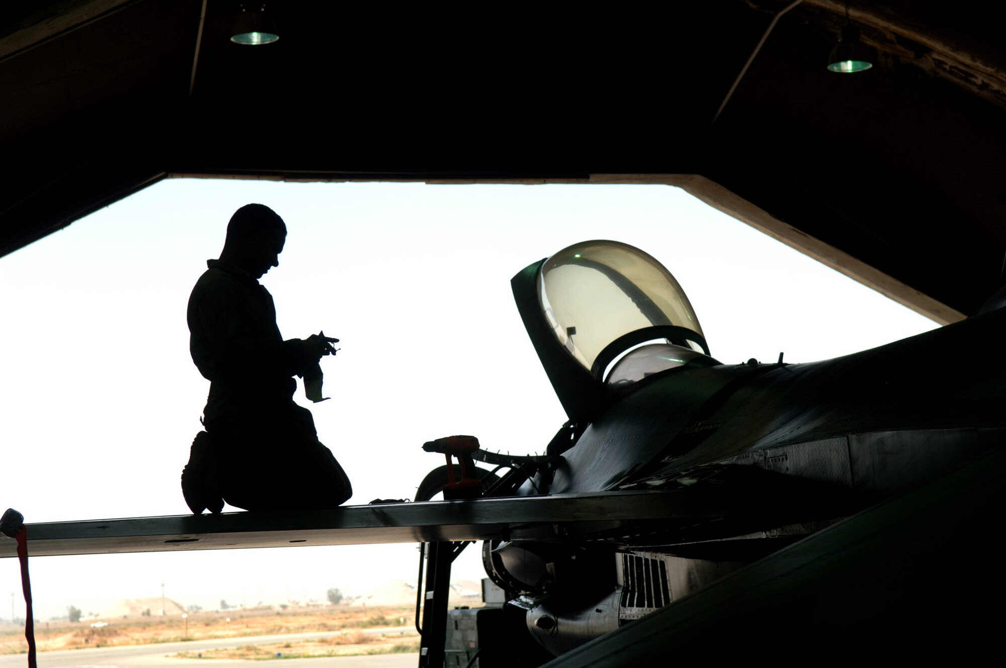 Senior Airman Gil Alicea removes panels from the left wing of an F-16 Fighting Falcon during a phase dock inspection April 16 at Balad Air Base, Iraq. Maintainers inspect all internal parts of the F-16 every 400 flying hours to keep the aircraft mission-ready. Airman Alicea is an F-16 crew chief with the 332nd Expeditionary Maintenance Squadron. (U.S. Air Force photo/Airman 1st Class Nathan Doza) 
