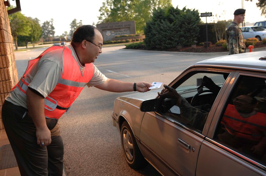SHAW AIR FORCE BASE, S.C. -- Juvenal Salomon, 20th Civil Engineer Squadron Environmental Flight, gives a driver a coupon for a free T-shirt for car pooling on Earth Day April 20. The base-wide Earth Day program, "Keep Shaw AFB Clean," raised environmental concerns to encourage cleaner daily practices.  Events included a base-wide cleanup, an electronic waste turn-in and an Arbor Day tree planting ceremony. (U.S. Air Force photo by Airman 1st Class Kathrine McDowell)