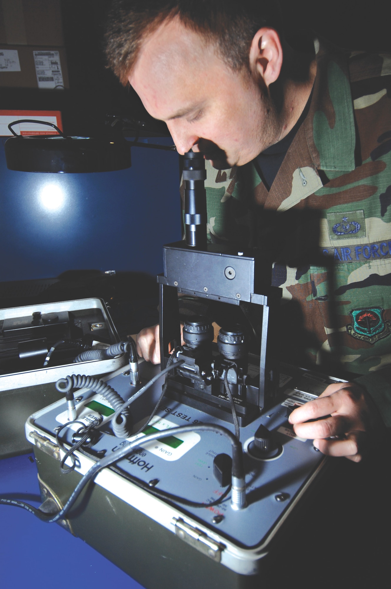 MCCHORD AIR FORCE BASE, Wash. -- Tech. Sgt. Anthony Scherer, 62nd Operations Support Squadron, uses a collimation bridge placed on top of a night vision test set  to ensure a pair of goggles are properly aligned and ready to be issued April 16, 2007 at the aircrew life support section warehouse. (U.S. Air Force photo/Abner Guzman)