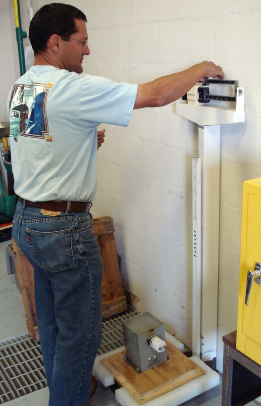 Tony Cedeno, 482nd Fighter Wing hazardous waster manager, weighs an electrical transformer as part of the hazardous waste disposal process.  After he weighs the transformer and files the appropriate paperwork it is turned in to the Defense Reutilization and Management Office for further transport to a HAZWASTE disposal facility.  The transformer contains only a small amount liquid that is considered HAZWASTE, but must be disposed of through proper channels according to Mr. Cedeno. (U.S. Air Force photo/Jake Shaw)