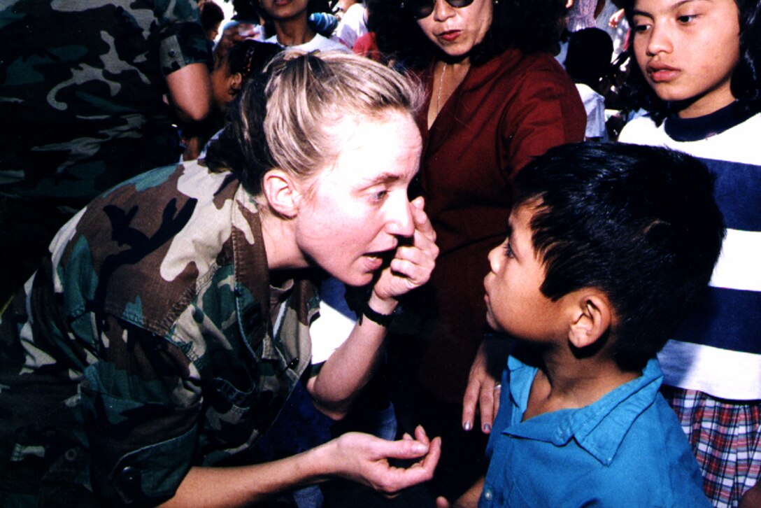Capt. Rachel L. Griffith, an emergency room nurse with the 86th Combat Support Hospital, examines a child at the St. Vincent de Paul Society Children's Home, San Salvador, El Salvador. As part of its Hurricane Mitch relief effort, the hospital unit sends teams twice weekly to areas needing medical care. Spc. Aaron Reed, USA