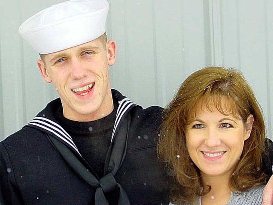 Sonya Schilling and her son, Seaman Joseph  Parenti, pose for family photos during a light January  snowfall in their hometown of Mount Sterling, Ohio. Parenti  was on a training break and headed off to the Navy Nuclear  Power Technology Command in Charleston, S.C., where he  hopes to become a nuclear propulsion plant operator. Photo  by Susan McKay.