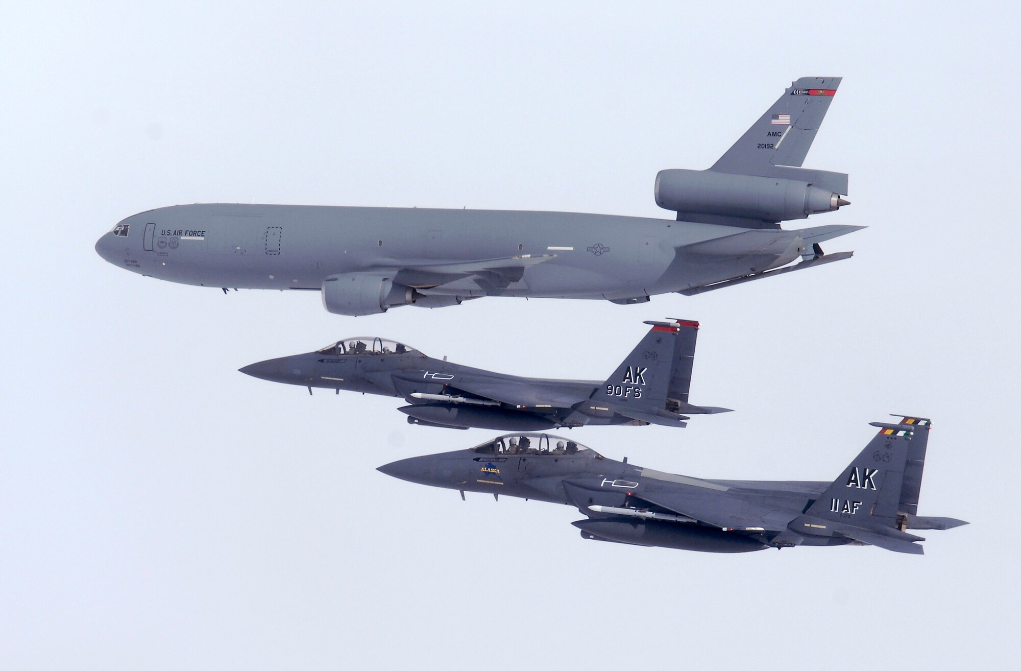 OVER ALASKA -- Two F-15E Strike Eagles fly along side a KC-10 from Travis Air Force Base, Calif. The Strike Eagle is assigned to the 90th Fighter Squadron at Elmendorf AFB, Alaska, which traces its history back to August 1917. Another chapter in that rich history is about to be written as the F-15E at Elmendorf will soon be replace by the F-22A Raptor. (U.S. Air Force photo by Tech. Sgt. Keith Brown)