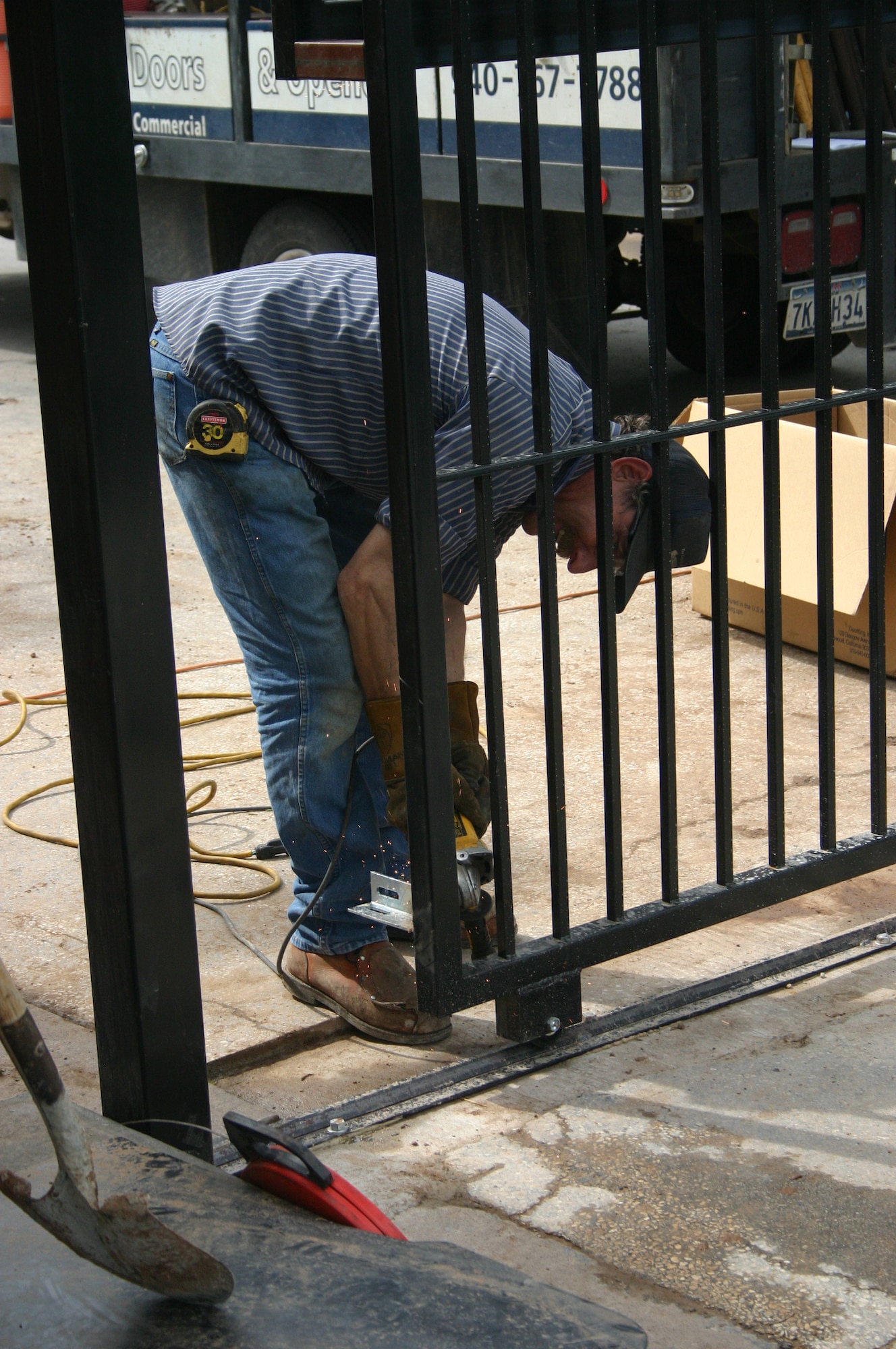 Horst Schmegmer, an employee of Overhead Door/Price Fencing Wichita Falls, works on the new gate for Capehart Housing April 24. (U.S. Air Force photo/Staff Sgt. Tonnette Thompson)