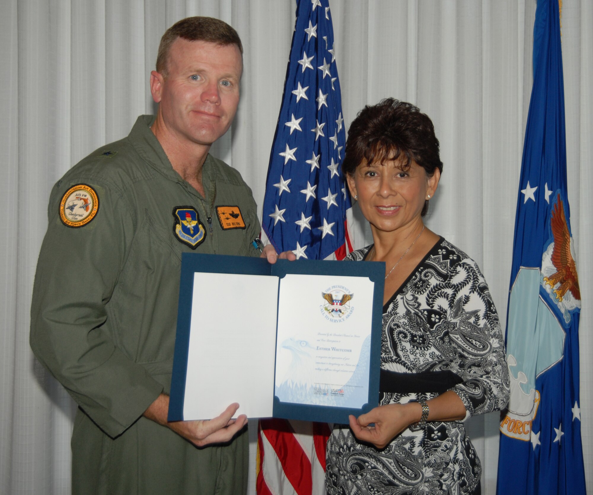 Brig. Gen. Tod Wolters, 325th Fighter Wing commander, presents the 2007 President's Volunteer Service Award to Tech. Sgt. Esther Whitcomb at Tyndall's annual Volunteer Recognition Monday.  Sergeant Whitcomb is a reservist at the 601st Air Operations Center here and served 3,240 hours as an active member of the Coast Guard Auxillary since 2003. (U.S. Air Force photo by Lisa Norman)