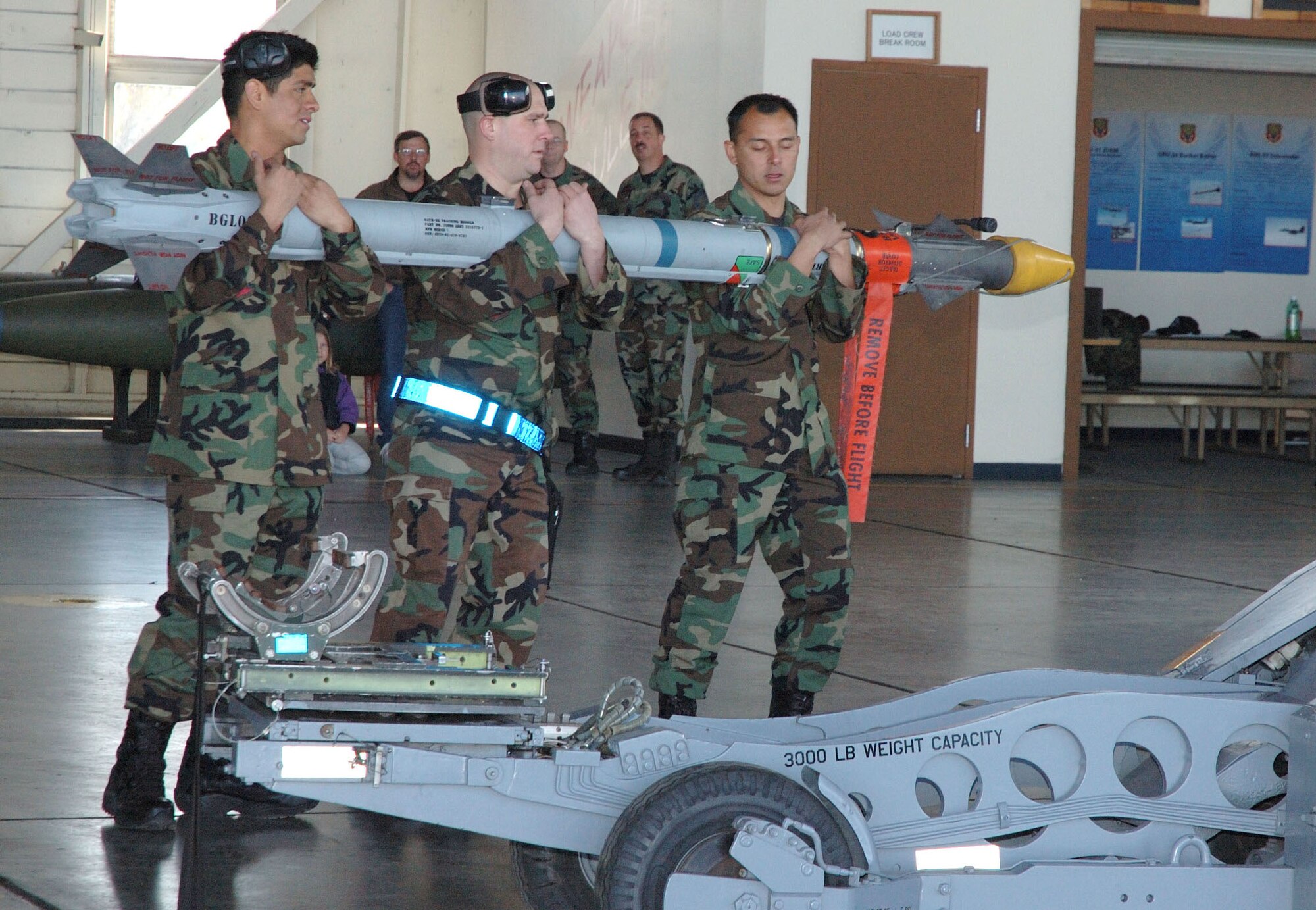 MOUNTAIN HOME AIR FORCE BASE, Idaho -- From left, Staff Sgt. Daniel Smith, Senior Airman Anthony Hodge and Senior Airman Arthur Villegas, all from the 390th Aircraft Maintenance Unit here, compete in the base's weapons load crew of the quarter competition April 23. The 390th AMU took the win with the 391st crew finishing second.  Air Force photo by Airman Samantha S. DeVries