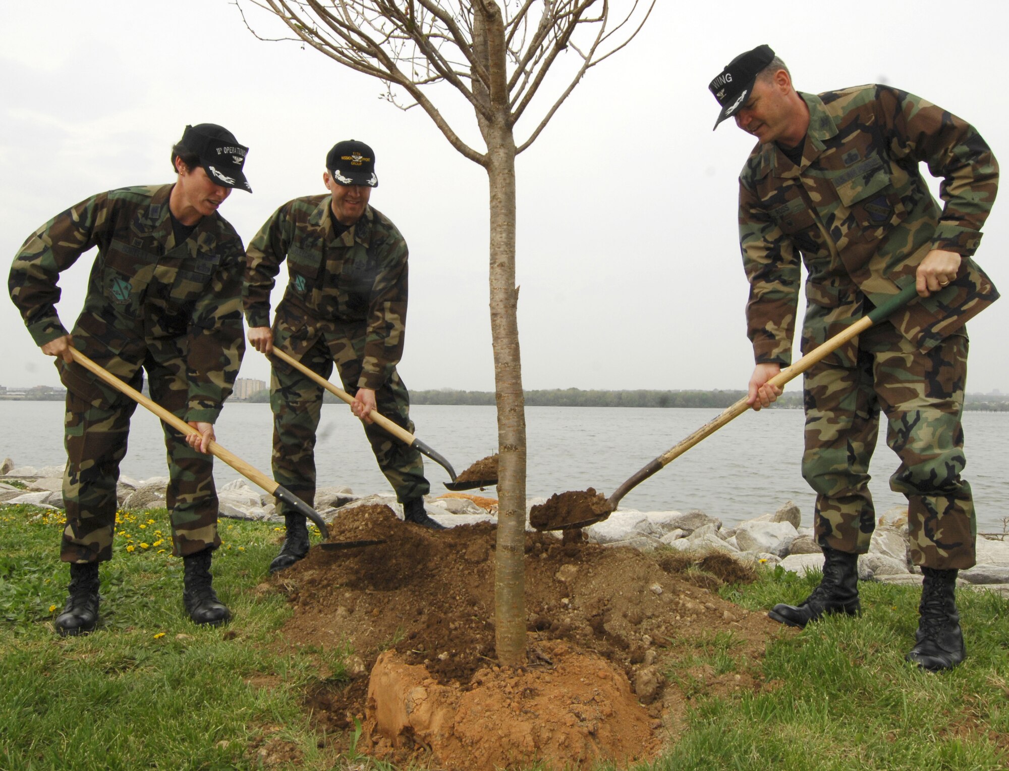 Col. Elizabeth B. Borelli (left), 11th Operations Group commander; Col. John M. Pletcher, 11th Mission Support Group commander; and Col Terry L. Ross (right), 11th Wing vice-commander, plant a cherry tree during the 11th Wing Earth Day celebration at the Bolling Marina April 24. The wing hosted the event in recognition of Earth Day which is observed annually on April 22 across the world.  (U.S. Air Force photo by Airman 1st Class Alexandre Montes)