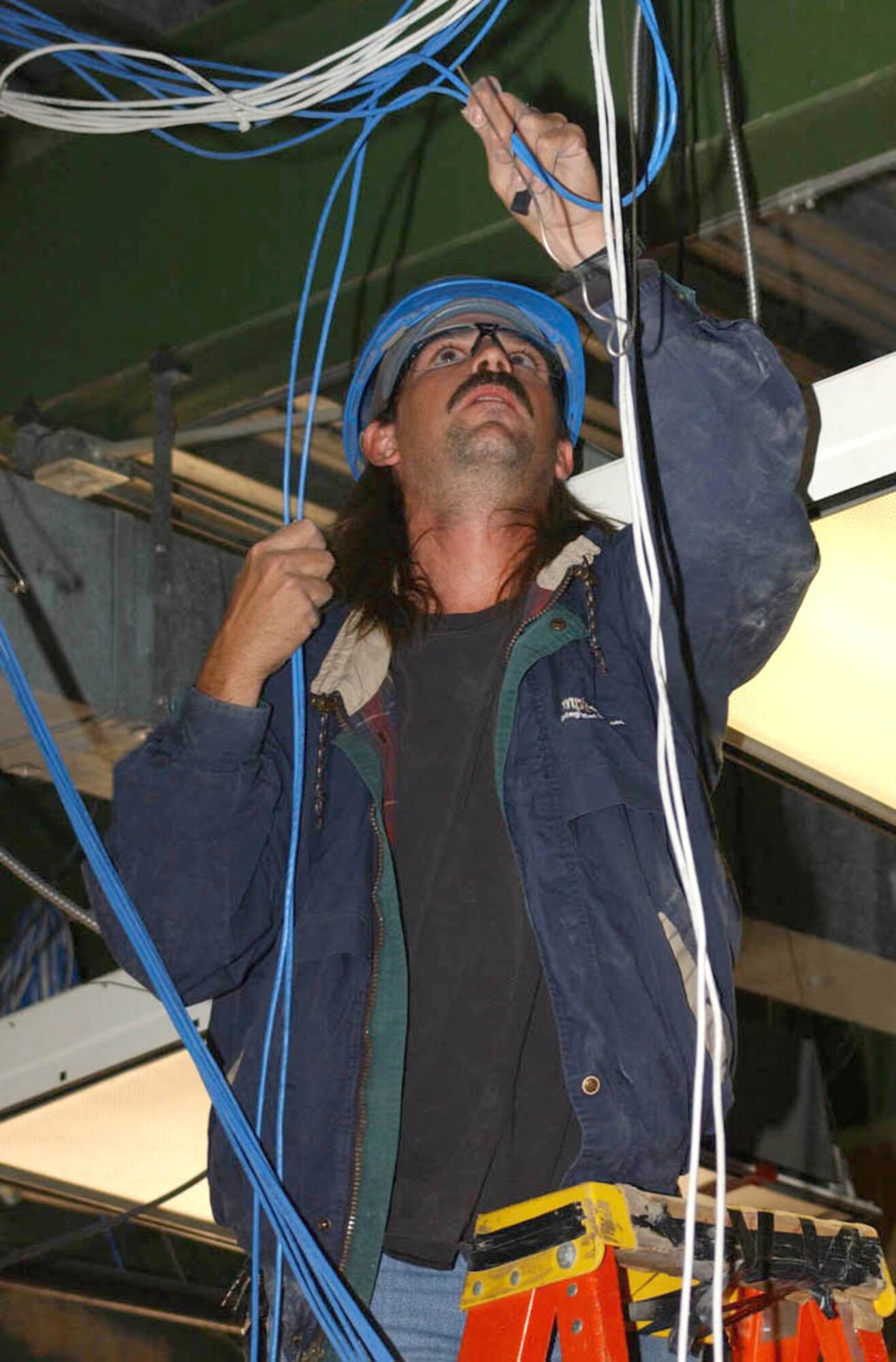Lead technician Donald Vincent of Empire Integrated Services of San Antonio pulls wiring for phone and data systems in Sablich Center.  (U.S. Air Force Photo by Kemberly Groue)