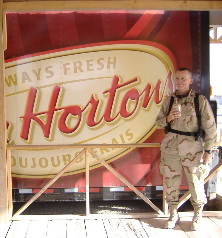 Lt. Col. James Horton stands in front of a familiar sign that bears his name while deployed to Iraq. A few moments with an iced coffee goes a long way in helping morale when deployed so far from home. Lt. Col. Horton is the 916th Communications Squadron commander and was just named outstanding field grade officer in his career field by Air Force Reserve Command. (U.S. Air Force photo/courtesy Lt. Col James Horton)