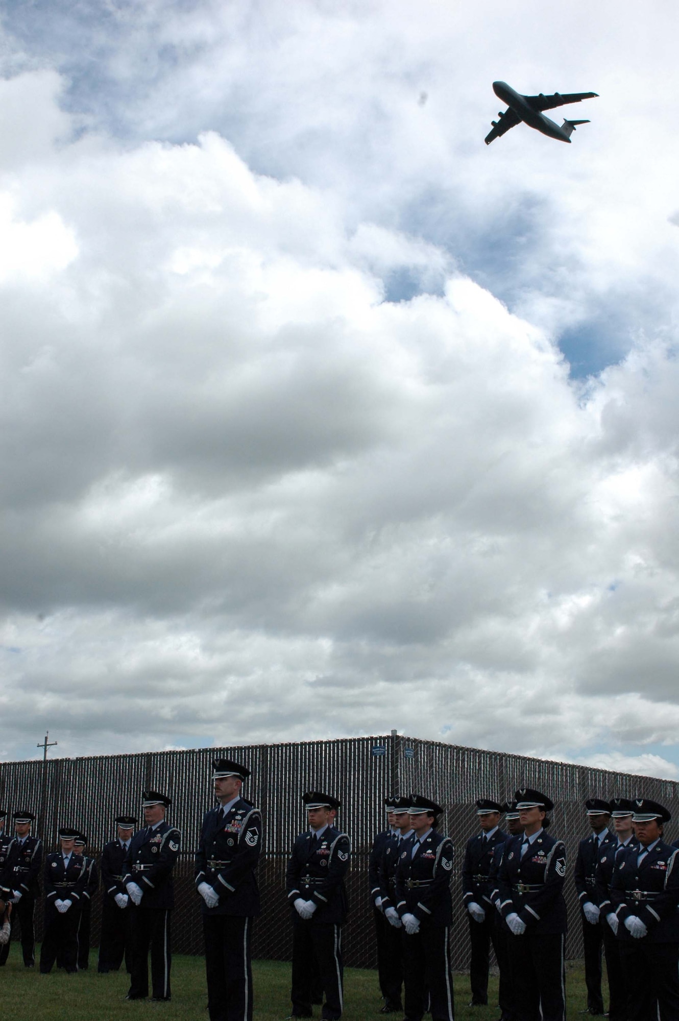 A C-5 Galaxy from Travis Air Force Base, Calif., flies over the Travis Honor Guard during the Sacramento Valley Veterans Affairs National Cemetery dedication ceremony April 22. Upon completion, the 110-acre site will provide 17,200 full-casket grave sites, 12,000 in-ground vaults, a 3,000-unit columbarium for above-ground placement of cremation urns and 765 sites for in-ground cremated burial. (U.S. Air Force photo by Jennifer Brugman)