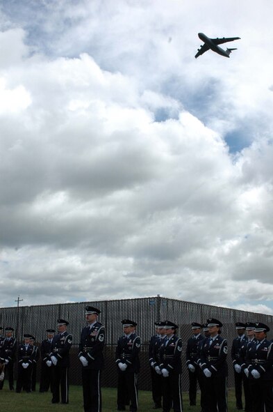 A C-5 Galaxy from Travis Air Force Base, Calif., flies over the Travis Honor Guard during the Sacramento Valley Veterans Affairs National Cemetery dedication ceremony April 22. Upon completion, the 110-acre site will provide 17,200 full-casket grave sites, 12,000 in-ground vaults, a 3,000-unit columbarium for above-ground placement of cremation urns and 765 sites for in-ground cremated burial. (U.S. Air Force photo by Jennifer Brugman)