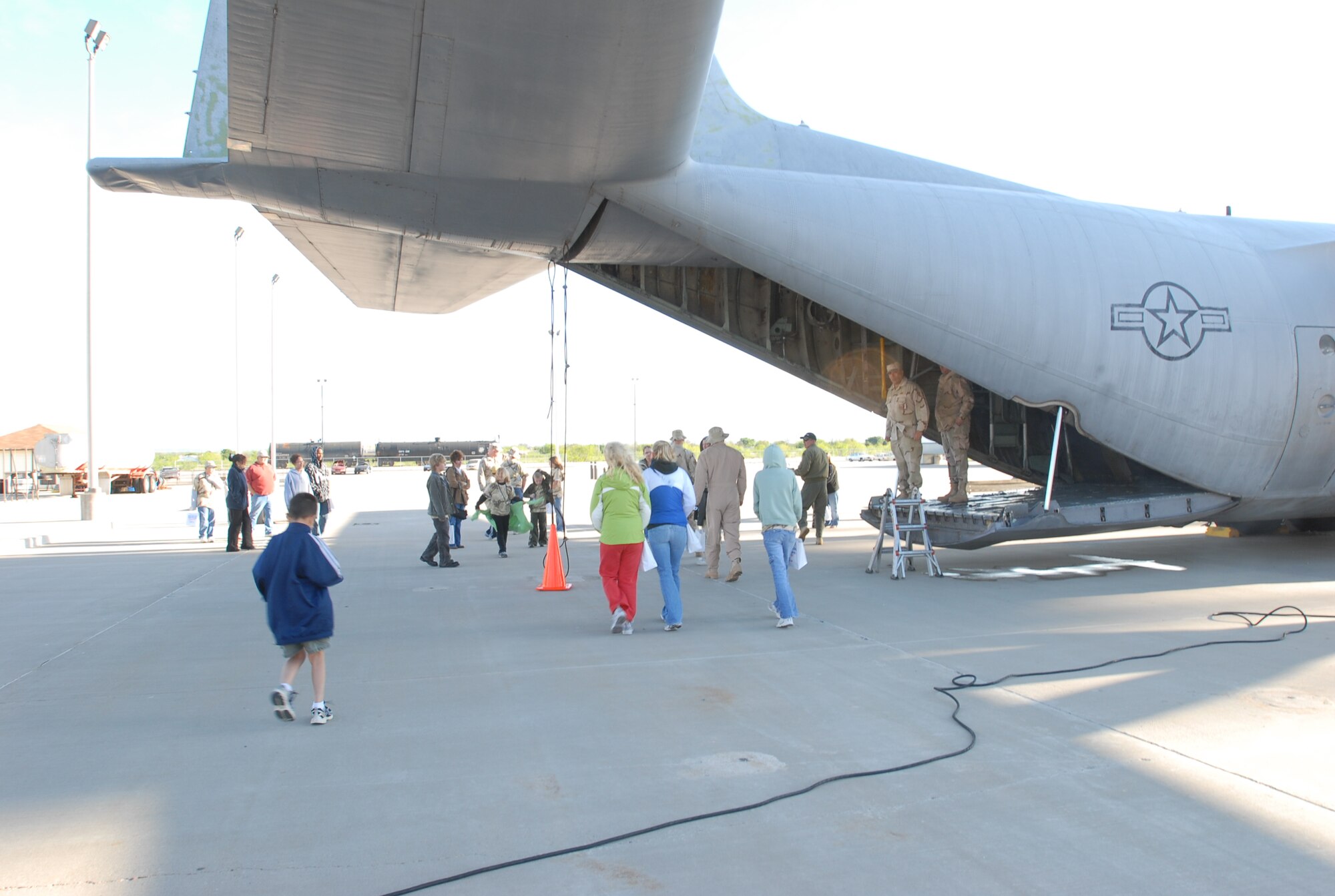 Operation KIDS deployees and their parents prepare to load into an inactive C-130 Hercules at the fire school, as they depart Camp Liberty for Discovery Air Base. (U.S. Air Force photo by Staff Sgt. Angela Malek)