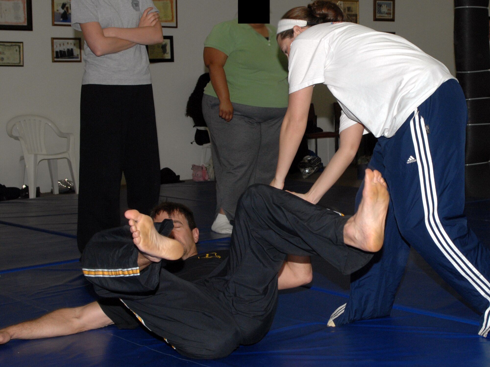 A participant in the “target hardening” self-defense course throws Paul Buckingham, Goodfellow’s Sexual Assault Response Coordinator, to the mat as she practices a self-defense technique. (U.S. Air Force photo by Staff Sgt. John Barton)