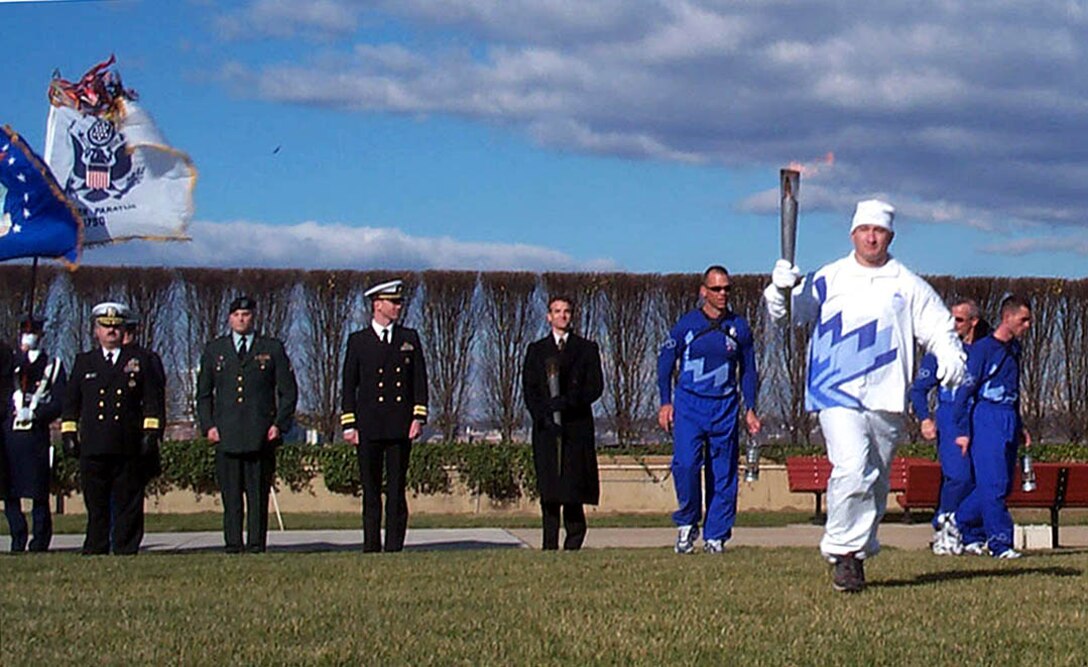 Army Sgt. Christopher Braman, carries the  Olympic flame at the conclusion of a Dec. 21, 2001,  ceremony at the Pentagon honoring the heroes and 184  victims of the Sept. 11 terrorist attack. Braman, who  risked his life to save three people, one of whom survived,  risk his life to retrieve the Marine Corps Flag in the  Pentagon. Photo by Linda D. Kozaryn