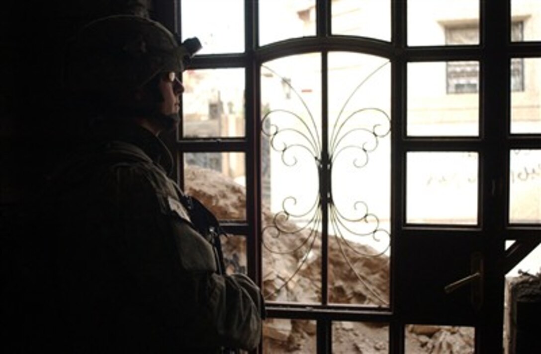A U.S. Army soldier from Charlie Company, 1st Battalion, 26th Infantry Regiment, 1st Infantry Division provides security from inside an unfinished building in the Adhamiya section of Baghdad, Iraq, on April 18, 2007.  