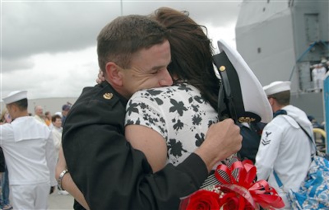 U.S. Navy Chief Petty Officer Brian Binder hugs his wife Kristine upon his return from deployment aboard guided missile cruiser USS Lake Champlain, April 20, in San Diego. Lake Champlain is part of the Ronald Reagan Carrier Strike Group returning after a three-month surge deployment in support of operations in the western Pacific. 