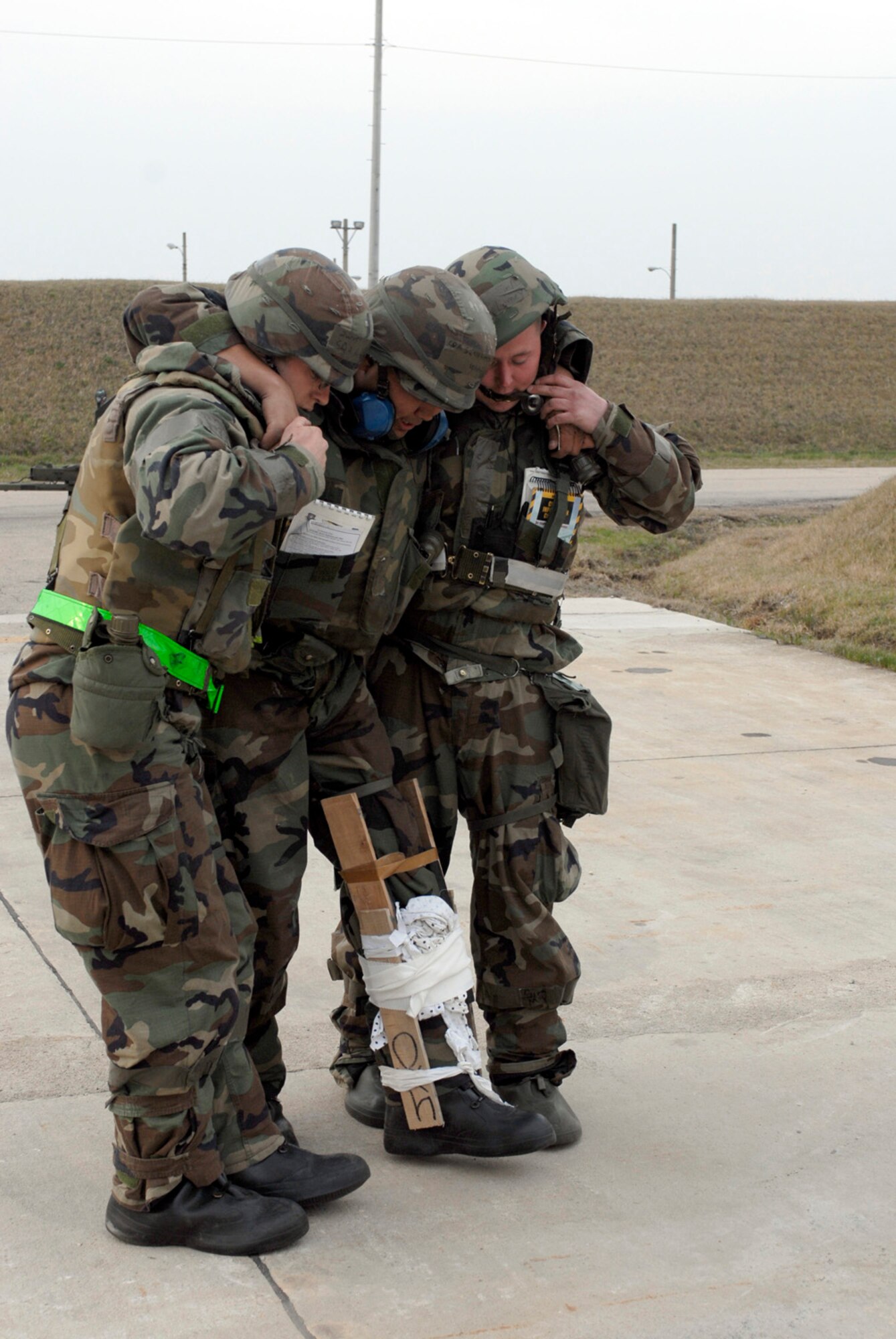 KUNSAN AB, Republic of Korea -- Senior Airmen James Herzog and Jason Lamey, provide help for injured Senior Airman Sean Simon-Okpealuk during a self Aid Buddy Care scenario here April 17. The 8th Fighter Wing is currently undergoing an operational readiness inspection to test its ability to conduct its wartime mission. (U.S. Air Force photo by Senior Airman Darnell T. Cannady)