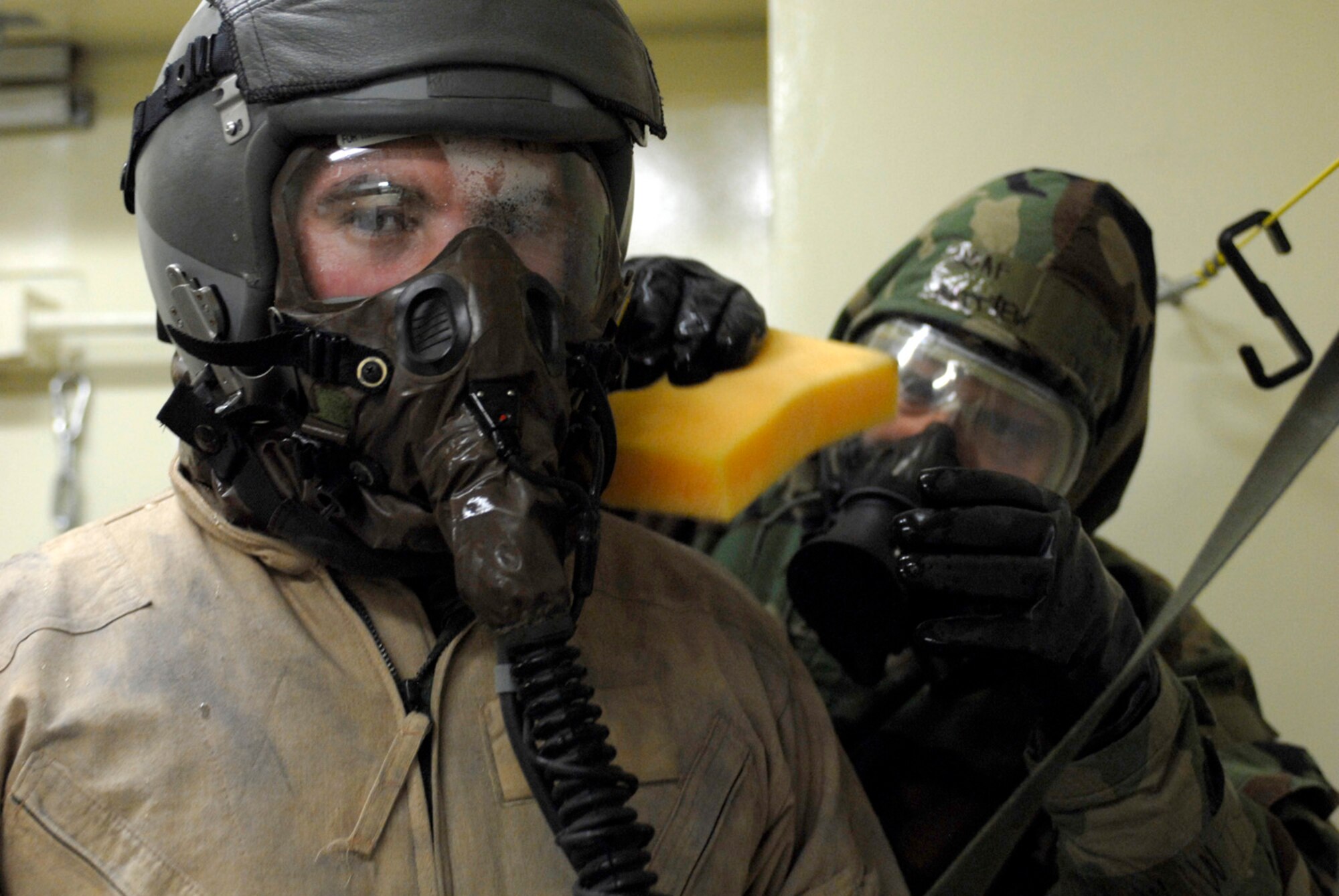 KUNSAN AB, Republic of Korea ? 1st Lt. Nathan Froh, 35th Fighter Squadron pilot, waits as Senior Airman Matthew Vincent, 80th Fighter Squadron washes off his gas mask during the pilot?s decontamination here. The 8th Fighter Wing is currently undergoing an operational readiness inspection to test its ability to conduct its wartime mission. (U.S. Air Force photo by Senior Airman Darnell T. Cannady)