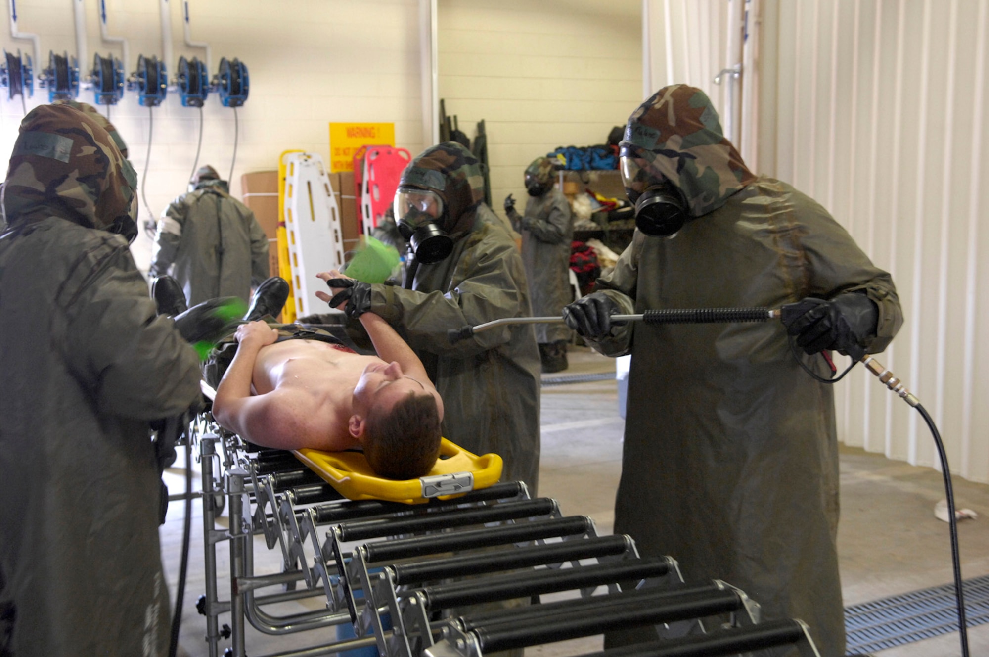 KUNSAN AB, Republic of Korea -- Medics from the 8th Medical Group use the proper procedures to decontaminate a patient with simulated injuries during an inspection here April 18.  The 8th Fighter Wing is currently undergoing an operational readiness inspection to test its ability to conduct its wartime mission. (U.S. Air Force Photo by Master Sgt Jack Braden.)