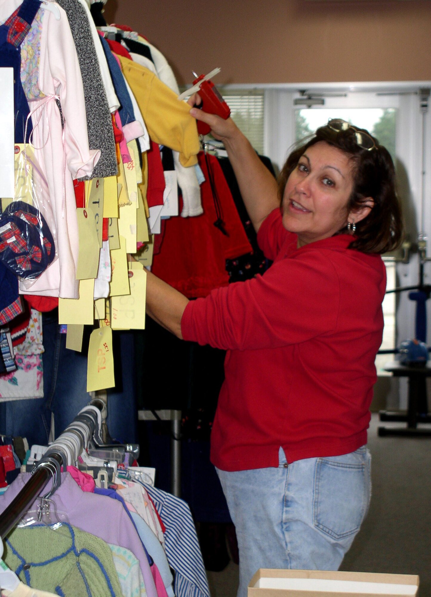 Sally Rodriguez, Yokota Officers' Spouses' Club volunteer, hangs clothing at the Thrift Store(courtesy photo)