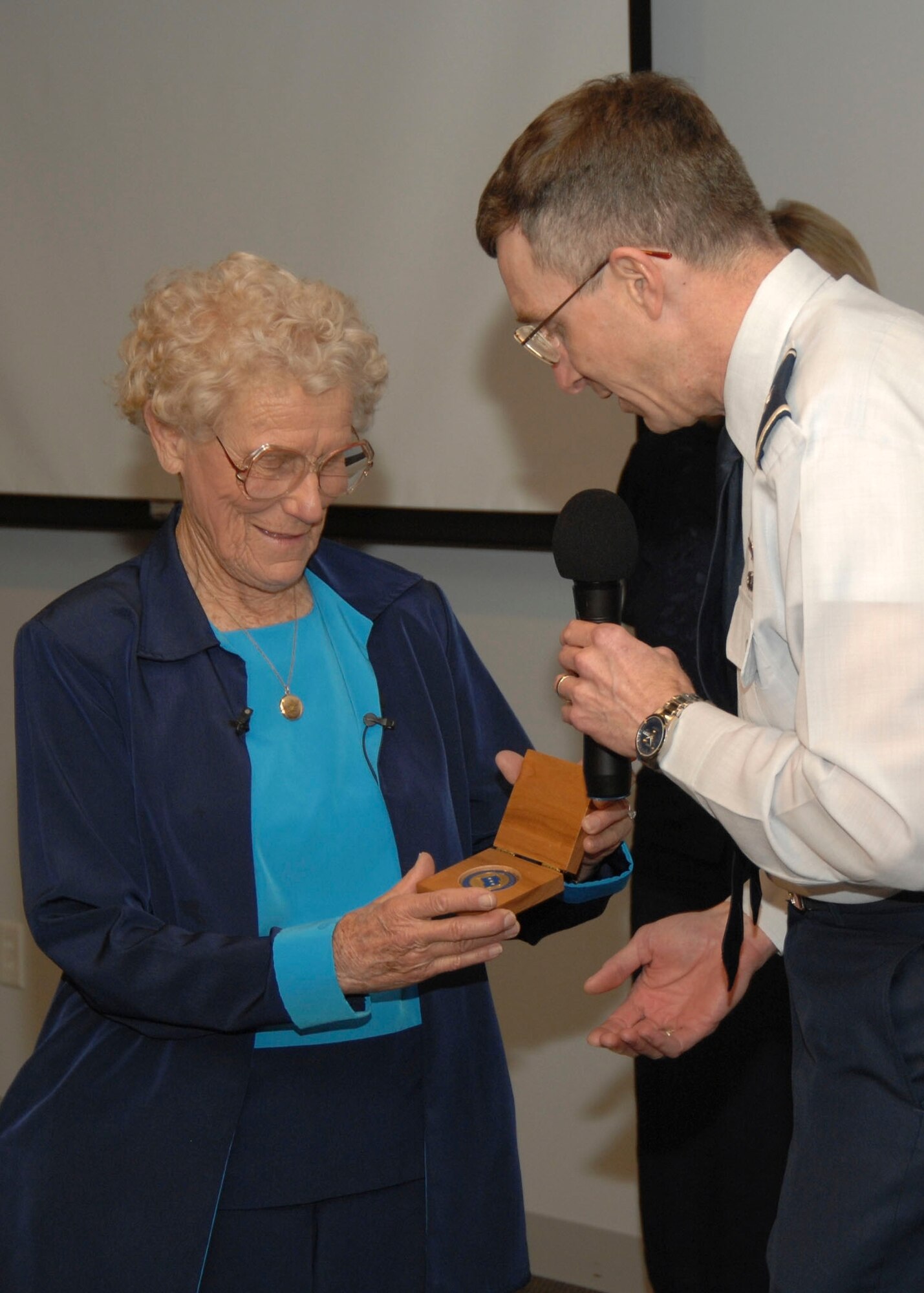 Iris Critchell receives an SMC coin from SMC Vice Commander Brig Gen. Neil McCasland. Mrs. Critchell, began her career in flight in 1939, spoke at LAAFB's Women's History Luncheon, March 28.