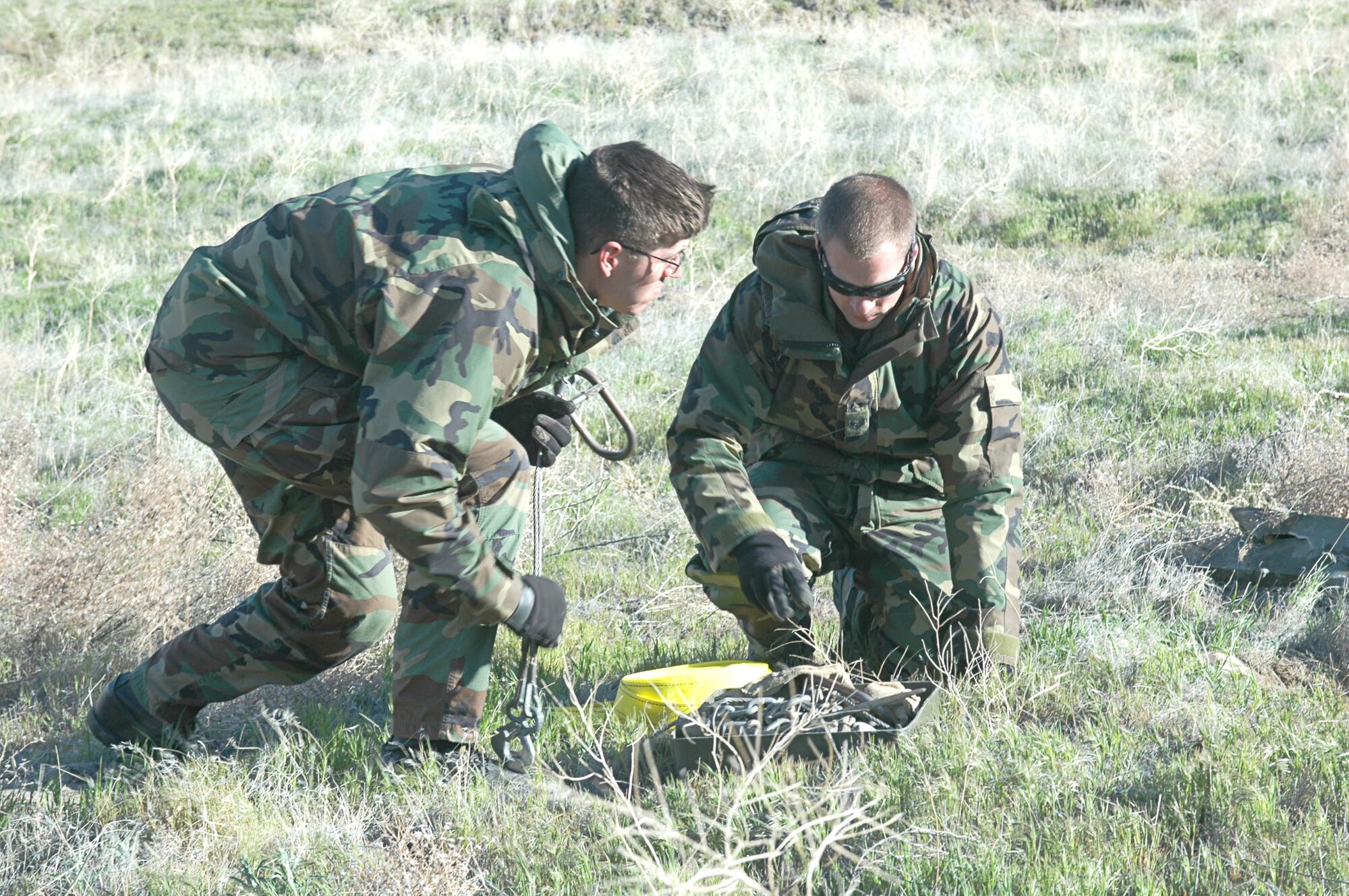 MOUNTAIN HOME AIR FORCE BASE, Idaho -- Senior Airman Noah Cheney and Senior Airman Joshua Harris, explosive ordnance disposal team members from the 366th Civil Engineering Squadron here, clear bombs from the Saylor Creek Bomb Range during clearing operations here April 24. The Airmen were part of a team sweeping the range for munitions dropped there over the past year. The base used people on the ground and in the air to complete the annual operation. Air Force photo by Airman 1st Class Ryan Crane