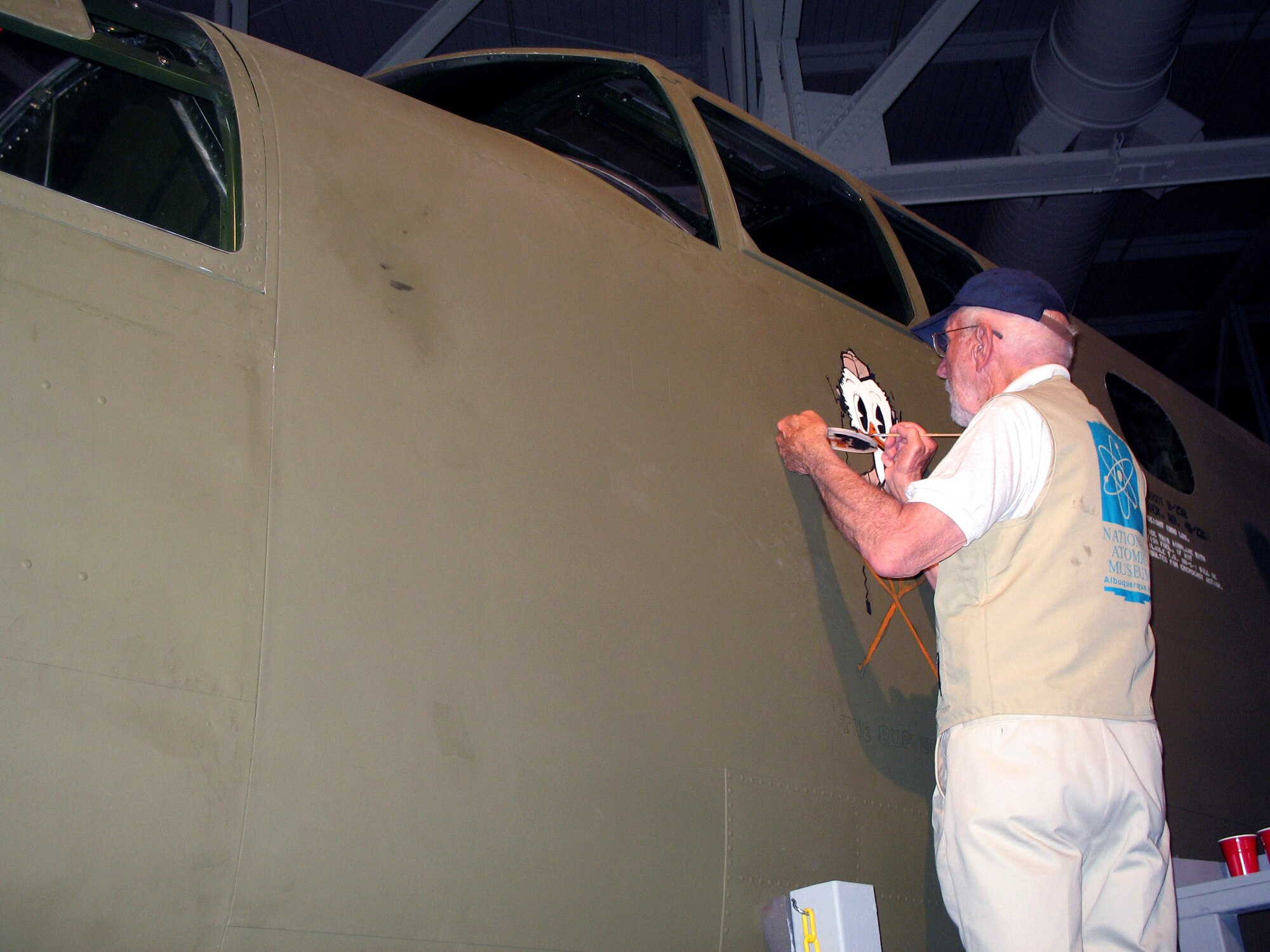 Hal Olsen touches up the paint on a B-25 Mitchell Bomber April 19 at the Pacific Aviation Museum in Hawaii. In honor of the 65th anniversary of the Doolittle Raid over Tokyo, Mr. Olsen was recreating one of his original nose art pieces, for the B-25 flown by Lt. Ted Lawson, one of the pilots involved in the raid. The piece called "The Ruptured Duck" is a symbol held in high esteem by World War II servicemembers. (U.S. Army photo/Army Sgt. Catherine Talento)