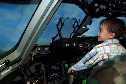 Zachary Moore, 3, son of Capt. Christopher, 437th Airlift Wing chief of public affairs, practices flying a C-17 in the flight simulator. Charleston AFB honored him in the Pilot for a Day program April 20 because he was diagnosed with cancer at 18 months. (U. S. Air Force photo/Airman 1st Class Nicholas Pilch)