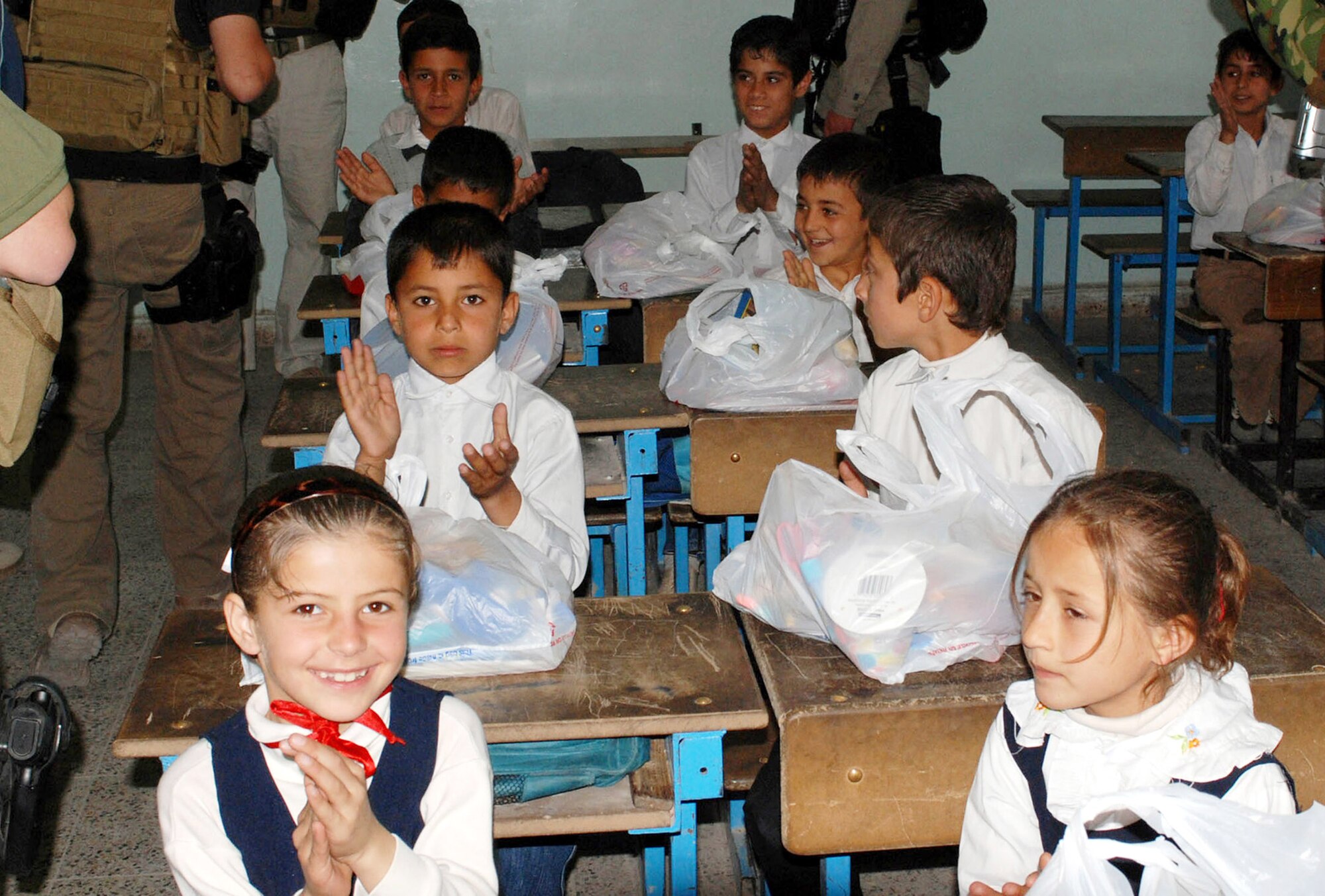 Children at a school near Kirkuk Air Base, Iraq, show their appreciation for their new school supplies delivered by Air Force Office of Special Investigations Expeditionary Detachment 2410 April 18. This effort is part of Operation Iraqi School Supplies sponsored by the 506th Air Expeditionary Group. (U.S. Army photo/Spc. Jaun Jimenez)
