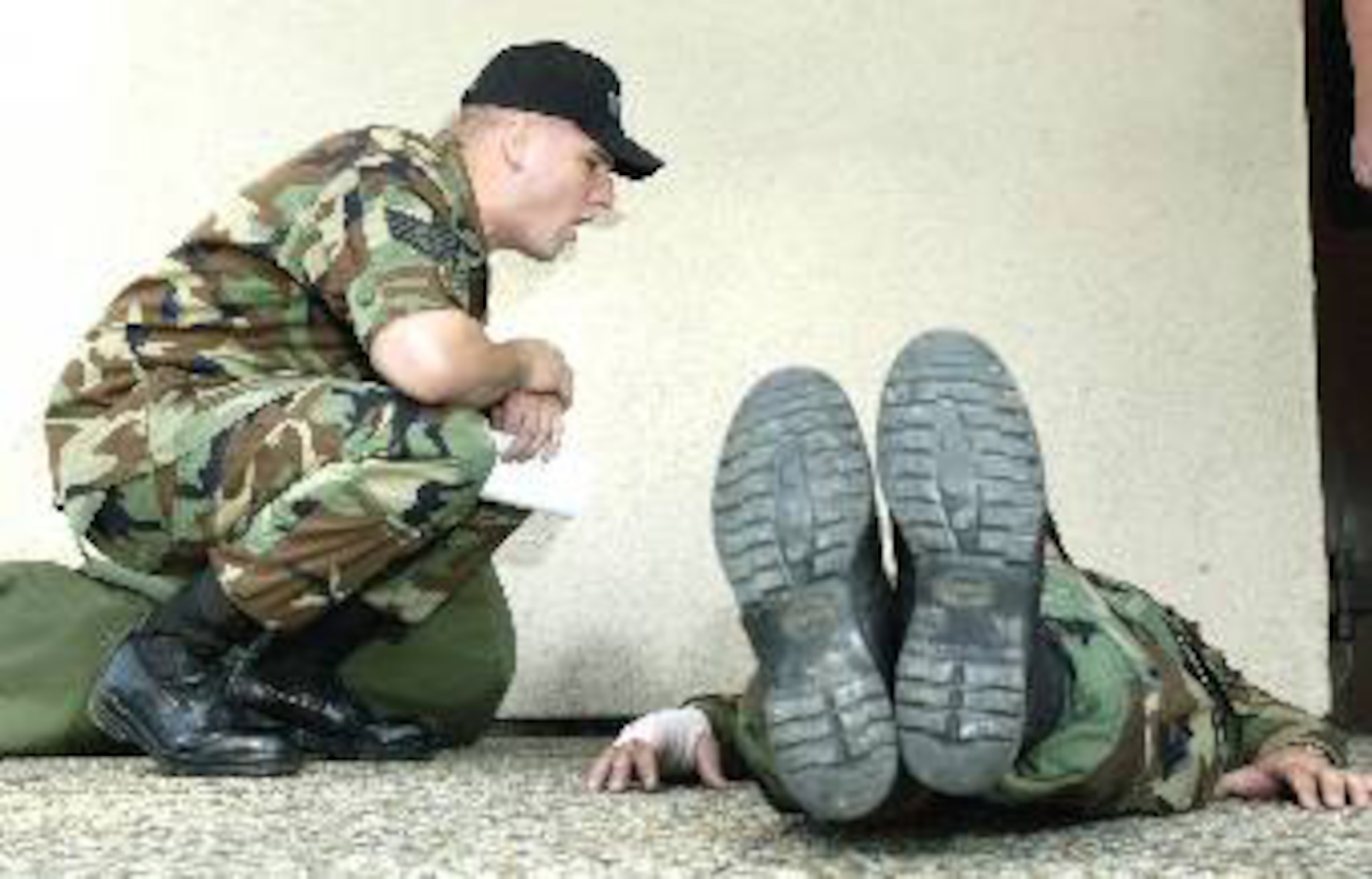 RAMSTEIN AIR BASE, Germany -- Staff Sgt. Mike Bowles asks a candidate who performs leg lifts why he is at Ramstein's Area Motivational Program. Sergeant Bowles "motivation" method is similar to what Airman Joshua Clendening, 317th Maintenance Squadron, endured during his time at Lackland Air Force Base, Texas, in March 2007. This 30-day program is used by commanders to "reblue" airmen basics through staff sergeants whose attitude or behavior has deteriorated, resulting in nonjudicial punishment. Ramstein's program was open from Jan. 2004 to March 2007. Lackland Air Force Base, Texas, and Keesler Air Force Base, Miss., are now the only Air Force bases that host remotivation programs. (U.S. Air Force photo by Master Sgt. John E. Lasky) 

