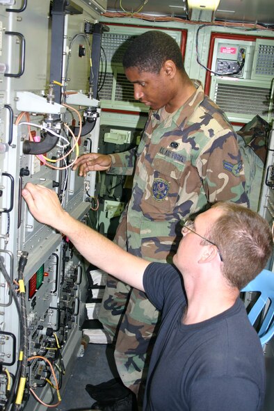SPANGDAHLEM AIR BASE, GERMANY – Senior Airman James Rogers instructs Airman 1st Class Jason Bracey, both from the 606th Air Control Squadron, how to adjust a high powered amplifier in a satellite communications terminal during a local training exercise. (US Air Force photo/Staff Sgt. Daniel Heise)
