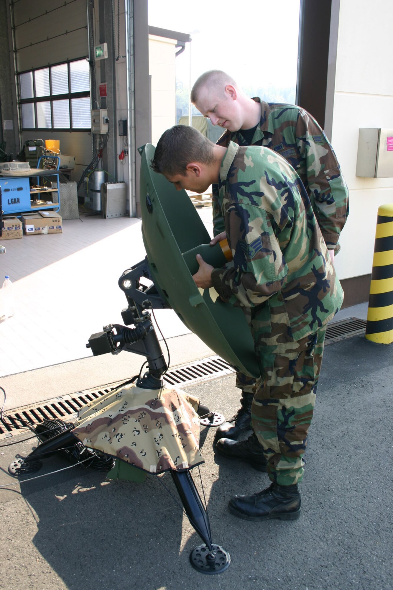 SPANGDAHLEM AIR BASE, GERMANY – Senior Airman Mark Sager and Airman 1st Class Caleb Roberson, both from the 606th Air Control Squadron, adjust a Global Broadcast System antenna’s polarization in relation to a satellite during a local training exercise. (US Air Force photo/Staff Sgt. Daniel Hiese)