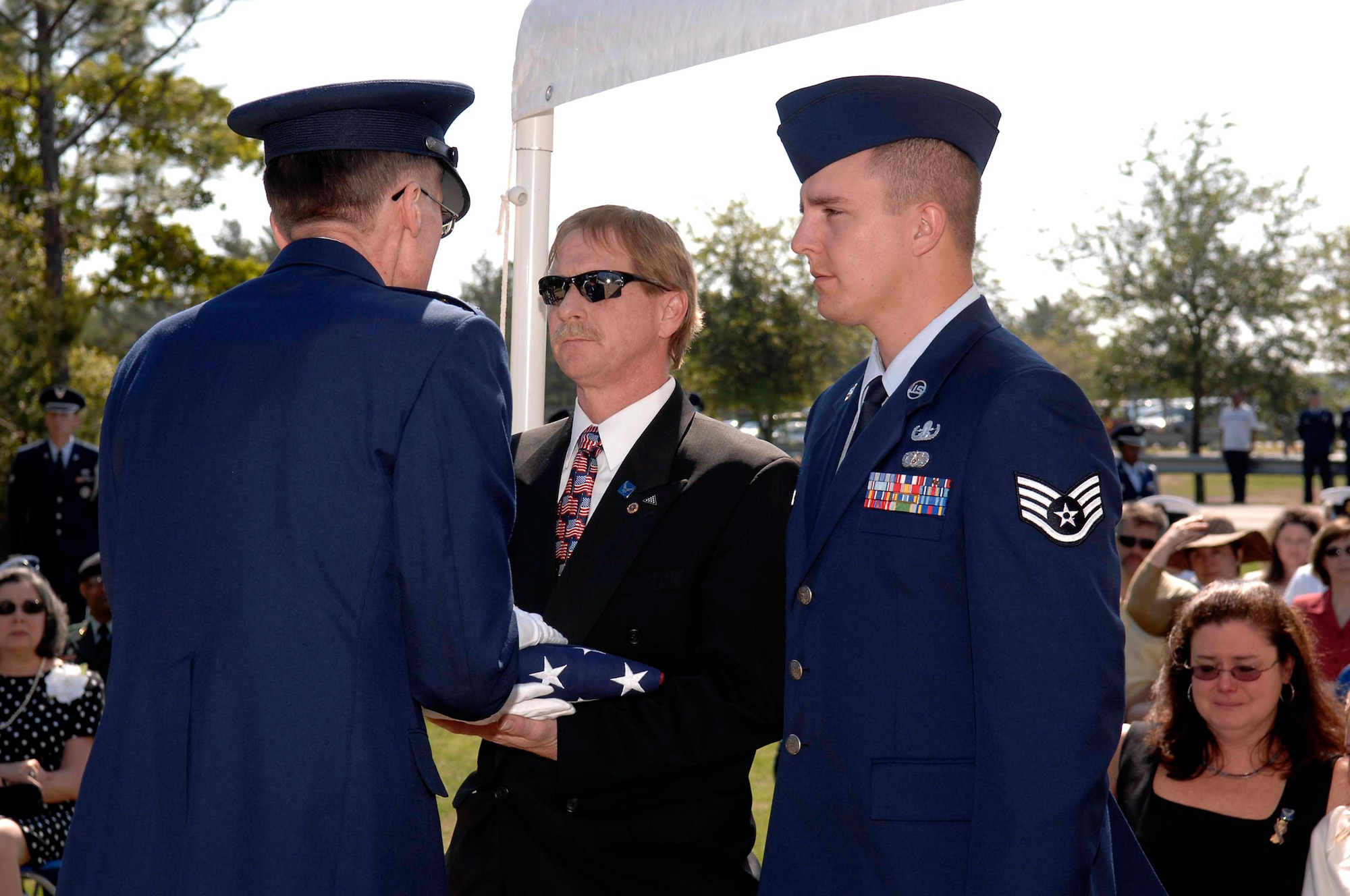 Lt. Gen. Donald Wetekam presents an American flag to Senior Airman Elizabeth Loncki's father, Stephen Loncki, and her fiance`, Staff Sgt. Jayson Johnson during the Explosive Ordnance Disposal's 38th Annual Memorial Service held April 21 at Eglin Air Force Base's Kauffman EOD Training Complex in Fla. Airman Loncki was killed Jan. 7 while responding to an improvised explosive device near Baghdad, Iraq. General Wetekam is the deputy chief of staff for Installations and Logistics Headquarters U.S. Air Force in Washington D.C. (U.S. Air Force photo/Bruce P. Hoffman)