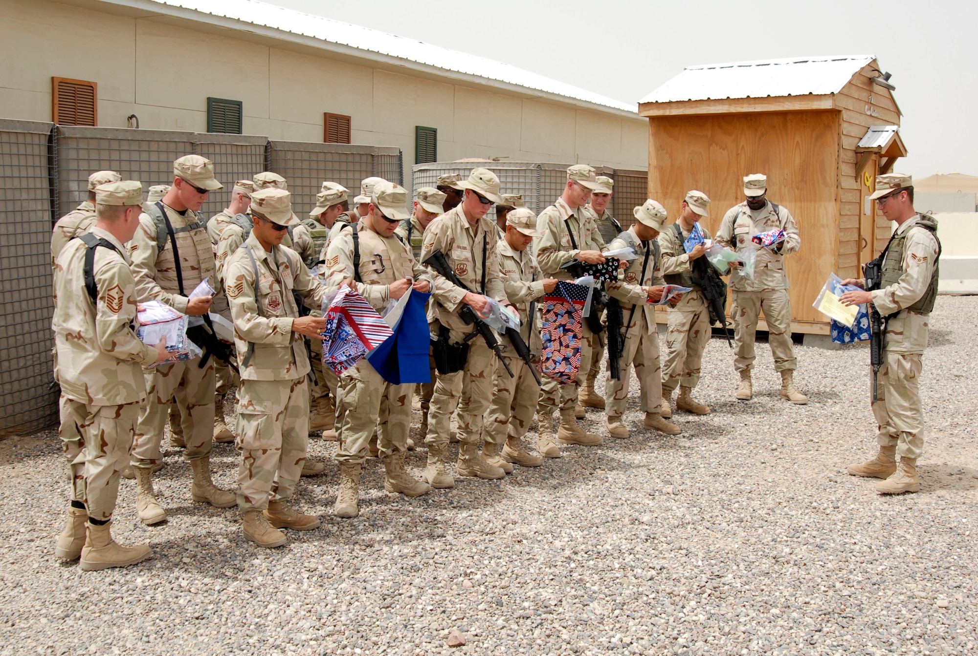 CAMP BUCCA, Iraq -- Members of the 886th Expeditionary Security Forces Squadron recieve pillow cases made and donated by the community of Concord, Calif. "Operation Pillowcase" ensured that every member of the 886th recieved a reminder of home. Spearheading the project was Mrs. Deborah Burrow, mother of Airman First Class Paul Beasley (at head of formation). (AF photo/Elias Ibay)